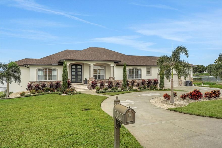 Welcome to 5911 Old Berkley Rd, a truly extraordinary lakefront estate nestled along the pristine shores of Lake Tennessee in north Auburndale. Set on over half an acre in a prime location just off Interstate 4, this 5-bedroom, 4.5-bath custom residence offers 4,281 square feet of beautifully designed living space, thoughtfully crafted for families who want luxury living with easy access to both Tampa and Orlando.

The elevated main level serves as the heart of the home, where expansive windows frame stunning views of the pool and lakefront beyond. The open-concept living and dining areas flow seamlessly into a chef’s kitchen appointed with quartz countertops, wood cabinetry, and premium appliances—an ideal layout for entertaining or everyday family life. Just off the main living area, you’ll find two dedicated offices—perfect for a his-and-hers setup, private den, or a quiet study and creative space.

The owner’s suite is a serene retreat with panoramic lake views, private porch access, and a spa-like ensuite bath featuring dual vanities and an oversized walk-in shower. A guest suite, powder bath, and laundry room complete the upper level. Downstairs, the walk-out basement-style lower level offers three additional bedrooms, two full bathrooms, and a spacious second living room/game room with direct access to the pool and lake—perfect for guests or multigenerational living.

The outdoor living spaces are equally impressive. A large covered patio leads to a sprawling pool deck and private backyard oasis. Beyond the pool, your private boat dock with covered slip and electric lift awaits—ready for summer tubing, paddleboarding, or a sunset cruise. A rear storage room is perfectly placed to hold all your pool and lake toys. The oversized 3-car garage offers high ceilings and abundant storage, ideal for boats, vehicles, and gear of all kinds.

This property blends refined interiors, functional design, and lakefront serenity with unmatched location convenience. Whether you're commuting to the city or enjoying the quiet escape of lakeside living, this is a one-of-a-kind opportunity to own a private retreat in one of Central Florida’s most desirable areas.