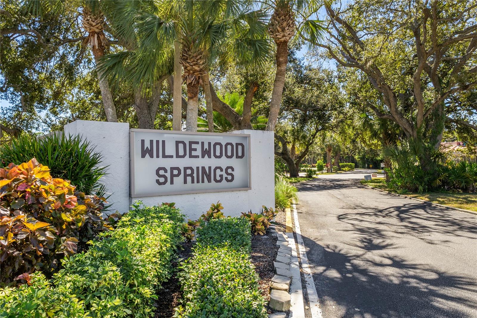 Welcome Home to Wildewood Springs! Discover this beautifully maintained ground-level 2-bedroom, 2-bath condo nestled within the serene bird sanctuary of Wildewood Springs. As you enter, you’re greeted by a light and bright kitchen featuring stainless steel appliances, granite countertops, a breakfast bar, and a convenient laundry closet. A large sliding door opens to the front patio, perfect for enjoying morning coffee or dining al fresco. The guest bedroom is ideally located near the updated second bath, complete with a stylish step-in shower and built-in bench. The open living and dining area showcases easy-care vinyl plank flooring and flows seamlessly to the spacious enclosed lanai, offering a perfect space for entertaining or relaxing. The oversized primary suite features an ensuite bath, walk-in closet, and sliding glass doors that fill the room with natural light and open to the lanai. Outside, enjoy your private paver courtyard, surrounded by tropical landscaping and complete with a rear gate for easy access. For added peace of mind, the electrical panel has been updated to the current code, and a dedicated car charger has been installed just off the front patio. Let’s not forget the amenities like several pools, tennis courts, canoe and kayak storage, several observation locations and so much more. Don’t miss your chance to experience the tranquil lifestyle of Wildewood Springs. Schedule your showing today and enjoy the best of Florida’s Suncoast this fall and winter!