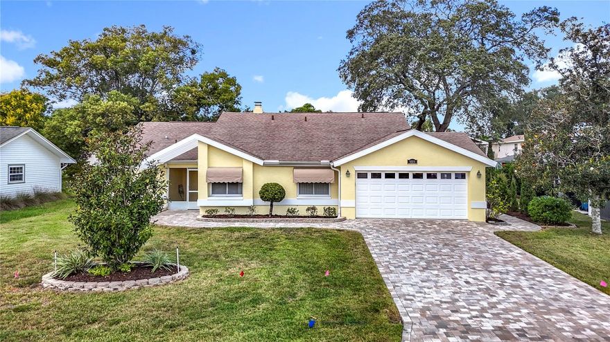 BRAND NEW ROOF TO BE INSTALLED PRIOR TO CLOSING.  Welcome to a residence where pride of ownership shines through every detail. This beautifully maintained 3-bedroom, 2-bath home boasts a host of contemporary upgrades and timeless touches, promising comfort, functionality, and effortless style. As you approach you will love the elegantly paved driveway and walkway, leading you to a tile-screened front porch—the perfect spot for morning coffee or evening relaxation. An updated front door welcomes you, while updated windows throughout the home enhance energy efficiency, security and curb appeal. Step inside to a tiled foyer that opens into a spacious living and dining room combination. Here, crown molding adds an air of sophistication while a tile-faced fireplace serves as a cozy focal point. Natural light streams through a solar tube, illuminating the space and creating a warm, inviting ambiance. The updated eat-in kitchen is a chef’s delight, featuring gorgeous cabinetry, sleek Corian counters, a stylish tile backsplash, and an abundance of thoughtful details: a built-in desk, under-cabinet lighting, a solar light, and sliding doors that invite you out to the lanai. Whether you’re preparing a gourmet meal or enjoying a casual breakfast, this kitchen inspires creativity and connection. Retreat to the generous master suite, where a walk-in closet and an additional standard closet offer plenty of storage and the en-suite bath pampers with dual sinks, Corian counters, and a beautifully tiled walk-in shower. The two additional bedrooms are equally spacious, sharing a well-appointed second bath with Corian counters and quality finishes. Enjoy year-round comfort in the lanai with its durable vinyl windows—a peaceful space for reading, entertaining, or simply taking in the outdoors from the comfort of home. The oversized 2-car garage is equipped with a mini split AC unit, workbench, cabinetry for organized storage, and a pull-down attic ladder leading to a floored attic for even more space. Additional features include dedicated laundry room with newer washer and dryer, newer exterior paint, gutters enhanced with leaf guards for easy maintenance, and a reliable AC system installed in 2017. Best of all, a brand-new roof will be completed prior to closing, offering peace of mind for years to come. This home harmonizes thoughtful upgrades with classic charm—ready for you to move in and make it your own. LOW HOA, NO FLOOD INSURANCE. Lots of shopping and favorite local dining options nearby. Minutes from the famous Weeki Wachee live mermaids, Pine Island Park and Roger’s Park for fun on the water. Close to the Suncoast parkway for quick access to the airport, Tampa, Clearwater and St. Pete Beaches (Ranked in the top 5 Beaches in the US), also close to the famous Tarpon Springs Sponge Docks. Enjoy everything Tampa Bay has to offer from the new Downtown Riverwalk, TOP US BEACHES, boating, fishing, golfing, cultural entertainment, and museums...and of course beautiful year-round weather! The community features Community Center which has the Library, Horseshoe Area, Shuffleboard Courts, Picnic Tables and BBQ Grills.
