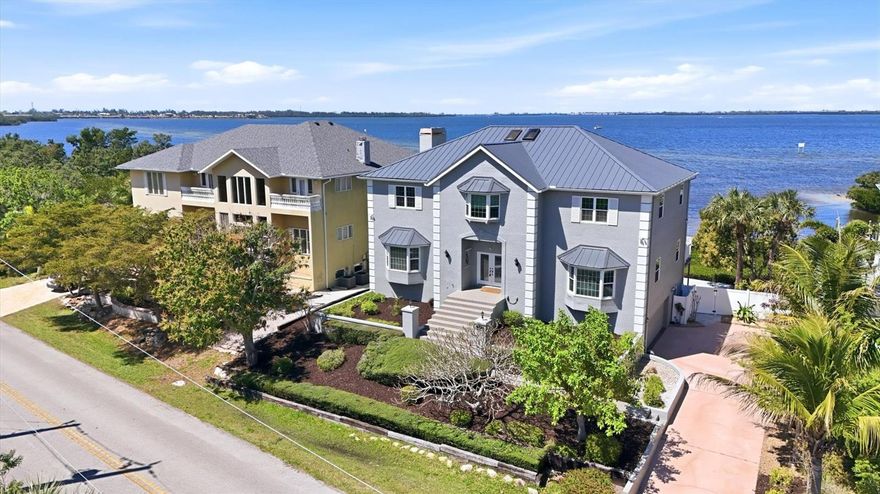 Experience breathtaking coastal living with unforgettable sunsets over Palma Sola Bay in this exceptional three-story waterfront residence with no HOA restrictions. Perfectly designed for both relaxation and entertaining, this home features a private wood dock with a seating area, a heated pool, and a beautifully pavered backyard deck surrounded by lush mangroves—where you can enjoy daily sightings of dolphins and migrating birds. Inside, the home showcases refined architectural details including grand arches, expansive windows framing stunning water views, elegant wood trim work, bay windows, and a sweeping curved staircase leading to the upper levels. The main living level on the second floor is adorned with imported granite flooring and offers a formal living room, formal dining room, a richly appointed den with wood paneling, and a spacious family room with a striking stone fireplace. The updated kitchen features new appliances and granite countertops (2021), along with a breakfast bar perfectly positioned to capture serene water views. The third floor hosts four generously sized bedrooms, including a luxurious primary suite complete with a private sitting area, fireplace, spa-inspired bathroom with dual vanities, soaking tub, walk-in shower, and a private deck overlooking the bay. A private elevator services all levels for added convenience. The ground level offers additional flexible space with four non-conforming rooms for ample storage or all your entertaining needs! Extensive upgrades include hurricane impact windows and doors (2023), a refinished pool and pavered deck (2023), a new metal roof (2025), and fresh interior paint (2026). An oversized two-car garage with electric vehicle charging station complete the property. Ideally located with quick access to Anna Maria Island, Longboat Key, Bradenton, Sarasota, and the vibrant UTC Shopping District, this home offers the perfect blend of privacy, luxury, and convenience in a truly spectacular waterfront setting.