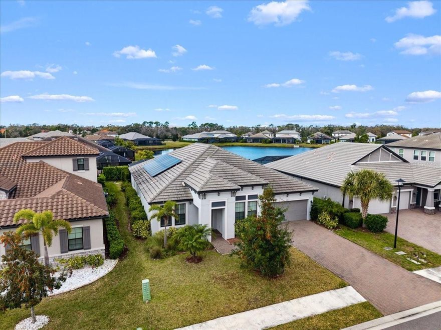 Modern & Pristine, this exceptional 4-bedroom, 3-bath residence with a sparkling pool and spa captures serene water views and effortless style. Thoughtfully upgraded throughout, the home showcases wood-look plank flooring, tray ceilings, designer lighting and fans, pendant accents, and added recessed illumination for a warm, modern glow. Expansive sliding glass doors open wide to the lanai for seamless indoor-outdoor living. Each bath is finished with solid wood cabinetry, Cambria quartz countertops, and sleek frameless glass enclosures. A generously sized laundry and utility room, dedicated pool bath, mudroom/drop zone, and rain-glass front entry add both function and flair. The kitchen is a true centerpiece—featuring Cambria quartz surfaces, a stylish tile backsplash, shaker cabinetry, and GE Profile stainless steel appliances, including a gas cooktop with range hood and a wall-mounted double oven topped with convection microwave. A farmhouse sink, under-cabinet lighting, and an oversized walk-in pantry complete the space with both beauty and practicality. Step outside to a screened, paver lanai where a gas-heated pool and spa shimmer overlooking tranquil water views. The tandem three-car garage offers epoxy flooring, and the paver driveway enhances the home’s crisp curb appeal. ***BONUS: A leased solar panel system helps keep electric costs in check.***HOA AMENITIES Include: Community pool, outdoor kitchen, playground, dog park, and pickleball courts.***LOCATION HIGHLIGHTS: Convenient access to SR-64 and just moments from top-rated Lakewood Ranch schools—Gullett Elementary, Lakewood Ranch High, Mona Jain Middle, LECOM, and Manatee Tech East Campus. You’re minutes from shopping, dining, fitness studios, salons, vibrant nightlife, downtown Sarasota, Sarasota International Airport, award-winning Gulf beaches, Ellenton Outlets, and UTC’s premier shopping and dining scene.