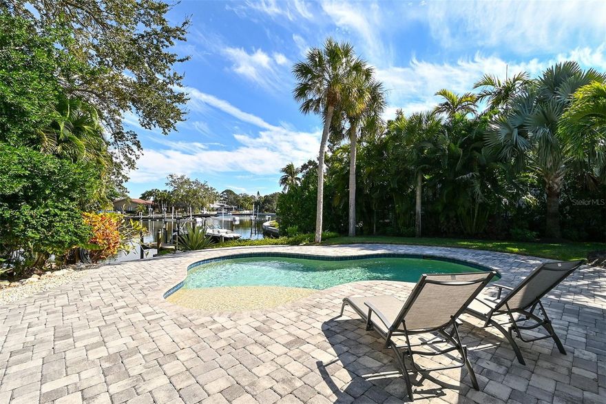Priced Reduced for Quick Sale! Step into your island paradise! Sold beautifully furnished, this stunningly renovated 4-bedroom 3 bath home is located in the highly sought after Siesta Isles neighborhood, just minutes to world renowned Siesta Key Beach.  From the moment you enter this fabulous home, you are met with an expansive open floor plan with water views across the entire back of the house.  Ideal for entertaining, this home affords multiple options for hosting, including a more-formal living room, dining area, a comfortable, cozy den with large screen television, a gourmet kitchen with sit-at bar, and a spacious screened and covered lanai with terrazzo flooring.  The  kitchen features all-white cabinets with black stainless appliances including a 5-burner gas cooktop, microwave/convection double wall oven, and wine refrigerator.  A  convenient pass-through window makes for easy food and drink service to the attached lanai. A split floor-plan, the master suite overlooks the pool and basin and incorporates a separate bedroom - perfect for young grandchildren.  At the opposite side of the house a third bedroom, fourth bedroom/den/office and bath are the ideal guest retreat.  New, large impact windows and sliders throughout the home allow for spectacular sunlight and vistas of the pool and basin.  A beautifully manicured lawn contains a heated salt-water pool and terrace to the basin.  White vinyl fencing at both sides of the lawn affords coveted privacy. A boater's dream, the dock supports a 10,000 lb lift  and a convenient launch for your kayak.  The attached two car garage has undergone recent enhancements including an epoxy-coated floor, steel cabinetry, and an impact exterior overhead garage door.  Whether you seek an entertainer’s dream home or a serene sanctuary to call your own, this property seamlessly combines both, offering the perfect balance of luxury and tranquility.  Welcome to your new paradise! Bedroom Closet Type: Walk-in Closet (Primary Bedroom).