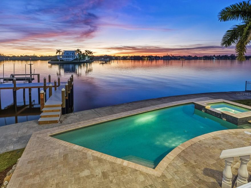 Substantial price change, $750,000 less. Positioned at the end of a quiet cul-de-sac, this exceptional bayfront residence is a haven for boaters and sunset enthusiasts alike. Set directly at end of a peninsula on the Intracoastal Waterway, the home enjoys sweeping open-water views and effortless access to the Gulf, while capturing breathtaking, mango-hued sunsets that paint the sky each evening. Designed to fully embrace its remarkable waterfront setting, the home offers gracious formal living and dining rooms alongside a warm and inviting family room with fireplace, seamlessly open to a chef’s kitchen appointed with high-end appliances and generous workspace, ideal for entertaining against a backdrop of ever-changing bay views. Walls of glass invite the outdoors in, opening to a terrace-style balcony overlooking the water, where evenings unfold with glowing skies and gentle bay breezes. From the terrace-style balcony, the home transitions naturally down to a resort-style bayfront heated pool and spa, and expansive waterfront yard, creating a stunning setting for alfresco dining, relaxation and waterfront gatherings. Boaters will appreciate the private bayfront dock and lift, protected Intracoastal waters ideal for kayaking and paddleboarding, and daily encounters with dolphins and abundant marine life, all enjoyed right from the comfort of home. The primary bedroom suite encompasses the entire top floor, creating a private sanctuary above it all. Thoughtfully designed for tranquility and privacy, the suite features expansive bay views, a private balcony positioned for sunset watching and a spa-inspired bath designed for relaxation. This serene retreat offers an owner’s haven, secluded, elevated, and immersed in the beauty of the surrounding water and sky. Offering four bedrooms, four full baths and three additional half baths, the residence provides exceptional comfort and flexibility for family and guests. A three-car garage and a one-year-old metal roof complete the home, balancing refined elegance with everyday functionality. Quietly tucked away in Sarasota’s sought-after Coral Cove neighborhood, yet moments from world-famous Siesta Beach and Sarasota’s cultural, dining, and coastal attractions, this exceptional estate delivers an extraordinary waterfront lifestyle, where boating, sunsets and refined living come together in harmony. Tranquil, elegant and undeniably special.