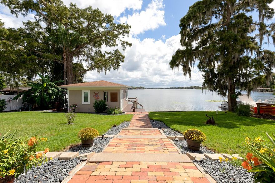 This spectacular Winter Park lakefront home is a very rare find indeed - exquisite inside and out! This home has been meticulously renovated and offers all the allure of fine lakefront living and is just minutes from Park Avenue’s shopping, dining and cultural gems. Situated on an oversized .39 acre lot this residence enjoys a picture-perfect setting with long views of Lake Killarney. Superior craftsmanship and attention to architectural detail emanate throughout the 3,749 SqFt of living space. This impressive property features an inspired layout starting with the exquisitely designed public spaces and continues throughout the rest of the home. The spacious owner’s retreat offers large windows overlooking the lake, customized walk-in closets, and just completed $60K bath renovation with a large walk-in shower, luxurious fixtures & finishes. There are 3 additional bedrooms: one with an ensuite bath and two with a shared bath. Additional amenities include a great room with floor to ceiling windows overlooking the lake, stacked stone gas fireplace, 26’ vaulted ceiling; gourmet kitchen with custom cabinetry, top-of-the-line stainless appliances, walk-in pantry. Other features include: built-in cabinetry, stone and hardwood flooring; whole house generator, solar panels pay for all the current electrical usage, 2 new HVAC systems, 4 wine cooler towers (600 Bottles) and an oversized two-car garage with EV charger, epoxy floor and storage cabinetry. Enjoy lakefront living under a 450 SqFt covered porch with a chef-inspired summer kitchen, electric shades, stacked stone wood burning fireplace, wet bar, epoxy flooring, tongue & groove ceiling and just steps away is a 275’ SqFt (Not Included in SqFt) air-conditioned boathouse with a coffered wood ceiling, covered boat dock, and deck.