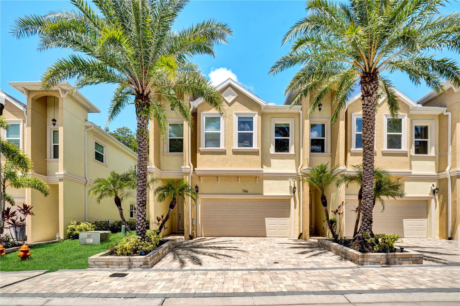 Welcome to this beautifully appointed 3-bedroom, 2.5-bath townhome with a 2-car garage, offering 2,275 sq ft of living space on a premium preserve-view lot in the sought-after Grand Cypress Trails community, nestled in the heart of Tarpon Springs. Built in 2022, this two-story gem combines style, comfort, and convenience — all just minutes from beaches, golf courses, the Pinellas Trail, and the charming, historic downtown area full of restaurants, shops, and entertainment.
From the moment you arrive, the paver driveway and covered entryway invite you into a home filled with modern upgrades and finishes. Inside, you'll find soaring ceilings, luxury vinyl plank flooring, and a spacious open-concept layout. The main floor features a large great room, an elegant dining area, a guest powder bath, and a gourmet kitchen with granite countertops, subway tile backsplash, stainless steel appliances (including a natural gas range), custom soft-close cabinetry with crown molding, upgraded fixtures, recessed LED lighting, and plantation shutters throughout.
Step through impact-resistant sliding glass doors to a screened-in lanai offering tranquil views of the private preserve, with a privacy shade and dedicated grilling area — perfect for outdoor entertaining.
Upstairs, retreat to the expansive primary suite, complete with a private balcony overlooking the preserve — ideal for enjoying sunsets or a quiet morning coffee. The luxurious en-suite bathroom features granite dual vanities, added storage cabinetry, upgraded mirrors, a walk-in shower, and both a standard and a custom-designed walk-in closet.
Two spacious guest bedrooms and a well-appointed full bath complete the upper level, along with a convenient laundry room featuring storage cabinets, a laundry sink, washer and gas dryer.