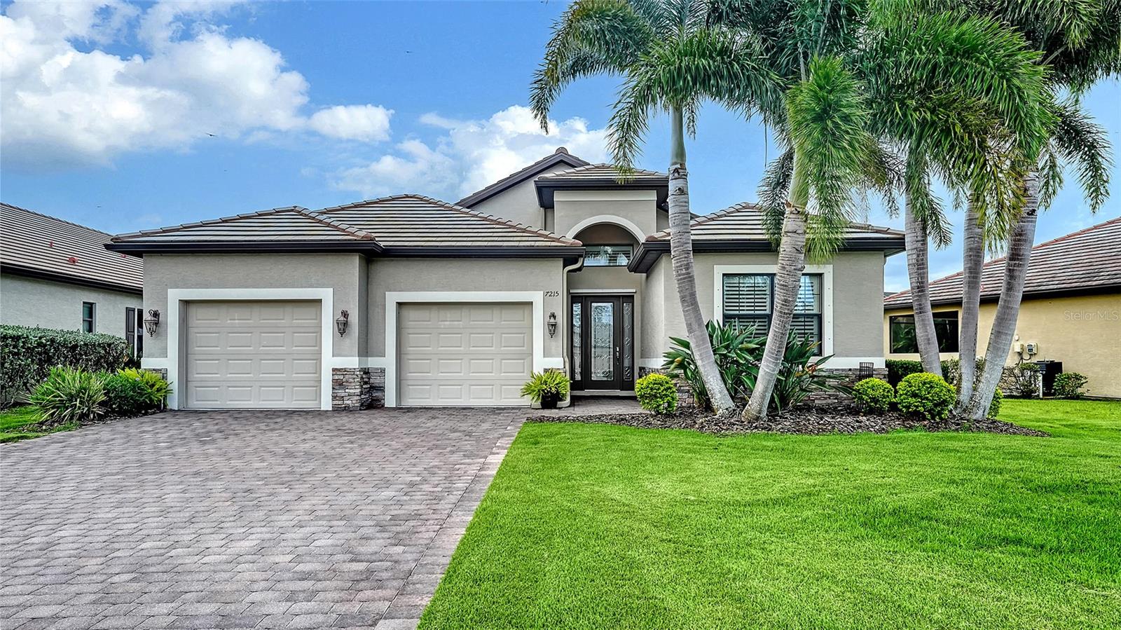 Timeless elegance awaits in this beautifully upgraded lakefront pool home. Nestled on a quiet cul-de-sac in the gated, maintenance-free community of Riva Trace. Built by Medallion Home and thoughtfully expanded and customized beyond the standard Granada model, this two-bedroom plus den residence offers a perfect blend of refined finishes and functional design in a serene, natural setting. Situated on a premium lakefront lot, the home welcomes you with a stately paver driveway and walkway, leaded glass front door, and impeccable landscaping. An open-concept layout designed for both comfort and effortless entertaining. High ceilings, crown molding, recessed lighting, custom wood and tile flooring, and well-appointed window treatments throughout. Spacious great room with tray ceiling and pocketing sliding glass doors that extend the living space onto the expansive lanai, where a heated saltwater pool and spa overlook peaceful lake views. Ideal for entertaining or relaxing in privacy with a large covered sitting area, open sunning space, bronze screen enclosure, and stone pavers that enhances the resort-like ambiance. The chef’s kitchen showcases 42” cabinetry with pull-out drawers, under-cabinet lighting, granite countertops, stone backsplash, GE Profile stainless steel appliances, built-in desk area, and a breakfast bar. Flowing effortlessly into a bright breakfast nook and formal dining room. The luxurious primary suite has direct lanai access, two walk-in closets featuring custom built-ins, and an ensuite bath with large dual vanity with granite countertops, walk-in tiled shower with frameless glass enclosure, private water closet, and linen closet. A spacious second bedroom is served by a beautiful full bathroom, while the versatile den provides space for a home office or additional living space. Thoughtfully designed laundry room with Maytag washer and dryer, utility sink, storage closet, granite countertops, and built-in cabinetry. The oversized two-car garage was expanded by 6-feet and features two separate, staggered garage doors for improved aesthetics and easier access, along with built-in storage cabinets and upper shelving. The home’s floorplan was expanded to enlarge key spaces including 2 extra feet in the 2nd bedroom to accommodate a king bed, 2-feet in both the great room and breakfast nook, and a bumped-out foyer for added entry space. Located just steps from the community’s private conservation park with a kayak launch and scenic overlook of the Braden River. Riva Trace is a quiet enclave of just 86 homes with community-provided yard maintenance, and irrigation, all with no CDD fees. Ideally located just minutes from UTC Mall, Benderson Park, I-75, SRQ Airport, top-rated dining and shopping, and Sarasota’s vibrant cultural attractions and award-winning beaches. A true reflection of timeless, sophisticated style within a gated community in a prime location.