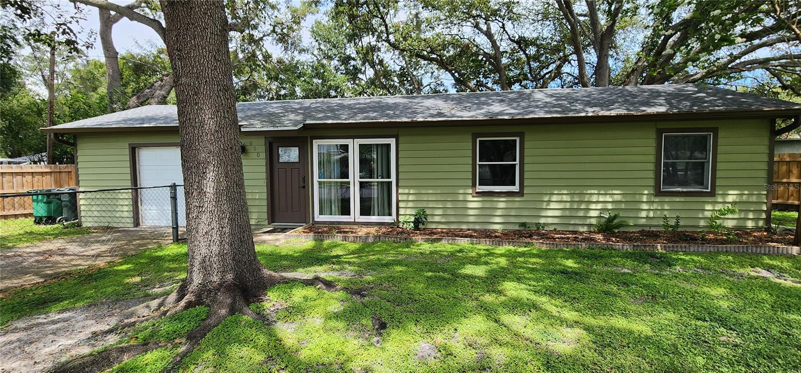 NEW PRICE IMPROVEMENT! You can be a Safety Harbor resident with this charming, affordable updated home on an oversized fenced lot. Enter the open living room and dining room and view the sweet backyard through double atrium doors with built in shades. Access the kitchen from the hallway or the dining area. Many upgrades include kitchen cabinets, counters and appliances, vinyl flooring throughout, bathroom vanity, sink, and bidet. New roof, kitchen and wood fencing were all installed in 2022. Separate laundry room with washer and dryer is inside! Garage with newer garage door has been a bedroom/family room in the past and can easily be reconverted into living area. Walk or ride to historic downtown Main Street with numerous shops and restaurants, special events and fabulous library. Very close to Philippe Park, The Marina Park and Safety Harbor Resort and Spa. Pedestrian and bike trail now goes into Tampa connecting Bayshore Blvd with the Courtney Campbell Causeway. This home is only footsteps from Safety Harbor Elementary School and Safety Harbor Middle School. Enjoy the freedoms of living in a non deed restricted neighborhood with NO HOA fee and NO flood insurance required. Life is good in the Harbor!