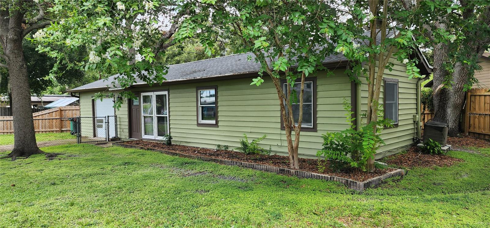 YOU CAN BE A SAFETY HARBOR RESIDENT with this charming, affordable updated home on an oversized fenced lot. Enter the open living room and dining room and view the sweet backyard through double atrium doors with built in shades. Access the kitchen from the hallway or the dining area. Many upgrades include kitchen cabinets, counters and appliances, vinyl flooring throughout, bathroom vanity, sink, bidet and exterior windows. New roof and wood fencing along rear and side of property were both installed in 2022. Separate laundry room with washer and dryer is inside! Garage with newer garage door has been a bedroom/family room in the past and can easily be reconverted into living area. Walk or ride to historic downtown Main Street with numerous shops and restaurants, Philippe Park, The Marina Park and Safety Harbor Spa. Pedestrian and bike trail now goes into Tampa connecting Bayshore Blvd with the Courtney Campbell Causeway. This home is only footsteps from Safety Harbor Elementary School and Safety Harbor Middle School. Enjoy the freedoms of living in a non deed restricted neighborhood with NO HOA fee and NO flood insurance required.