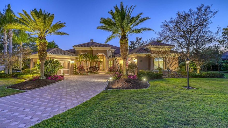 Beautiful custom Arthur Rutenberg builder model meticulously maintained by one-owner since built in 2006 on almost a full acre with big lake views in gated community.  Over 4,000 ac SF with 4 bedrooms and 5 ½ baths and garages for 3 cars.  At the time it was built the entire home was professionally decorated with furniture included in the price but negotiable.  Extensive use of tray ceilings with custom faux painting and columns throughout the house finished with faux pearl accents.  
As soon as you walk in the front door the view is amazing with high tray ceilings and wide sliding glass enclosures that completely pull back enabling the pool cage to become an integral part of the home.  The pool cage is professionally landscaped with a special wide panoramic section to capitalize on large views of the lake.  The pool features two waterfalls with a built-in spa. At night, the pool area comes alive with beautiful colored lighting as well as around the perimeter of the cage.  The front and sides of the home also feature decorative exterior lighting.
Large designer kitchen with pull-out drawers inside all base cabinets has over-sized island with back-lit imported Italian Cristallo stone and unique kitchen faucet.  Custom built entertainment center has large pop-up tv with surround-sound is easily viewable from the kitchen.  There is another large tv in the media room and each bedroom has its own tv including the pool cage.
Large office with custom cherry cabinetry and wainscot paneling around walls includes an area for two computer workstations and full-size desk with two tall corner storage cabinets.
New carpet in bedrooms, ac/handlers replaced within last 3 years, pool re-finished, and pool cage re-screened.  Large garage has ac and both garages have epoxy floors.  The interior and exterior of the home was recently re-painted.
Gated neighborhood with only 33 Arthur Rutenberg custom homes with award winning community landscaping that has its own central irrigation system. Just the Italian Marble kitchen Island make you fall in love with this exquisite home.