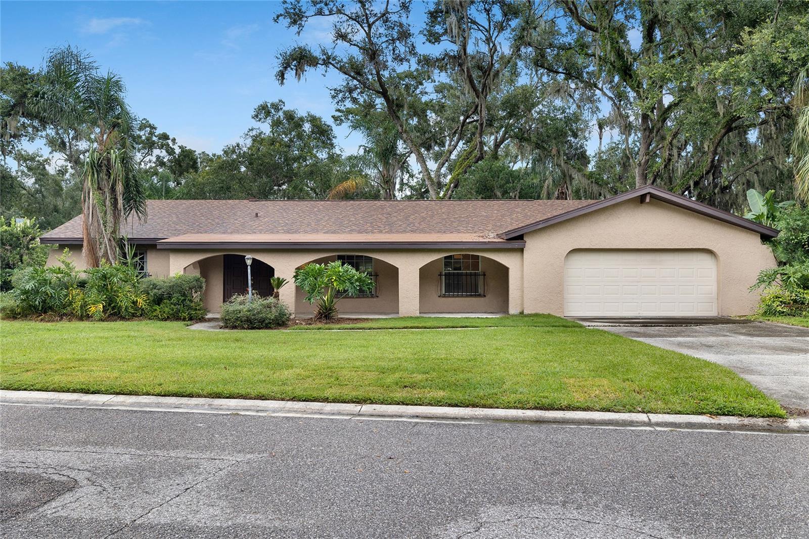 So much potential in one of the most sought-after neighborhoods in Temple Terrace! This solid all-block home sits high and dry in a non-flood zone on an oversized .33-acre lot and offers 3 spacious bedrooms, 2 full baths, a 2-car garage, and 2,355 sq. ft. of living space — all with a brand-new roof in 2024! The split floor plan features a welcoming covered front porch, a formal living room and dining area, and a sprawling main living space with a beautiful brick fireplace as the centerpiece. Sliding doors open to a lush backyard with mature landscaping and a covered patio, perfect for relaxing or entertaining. The kitchen includes a cozy eat-in nook, nicely maintained walnut cabinets, and classic Formica countertops. The primary suite is oversized with walk-in closets and a flow-through double vanity bath, while two large guest bedrooms share a conveniently located full bath. With just a little TLC, this home could truly shine — offering incredible value for both investors and homeowners ready to make it their own. Temple Terrace Estates is a premier golf course community with an unbeatable location just minutes to USF, Florida College, Busch Gardens, major highways, shopping, and dining, plus amenities like an Olympic-size pool, fitness center, water slides, volleyball, pickleball, racquetball, tennis, and more. This is an incredible opportunity to get into one of the best neighborhoods at a great price — don’t let it pass you by!
