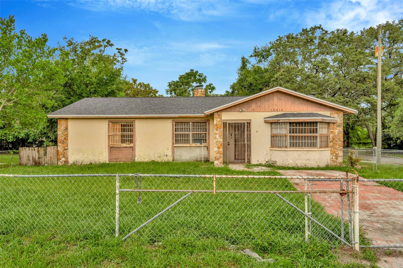 Opportunity is knocking with this corner lot gem in Tampa Overlook, offering 1,878 square feet of living space. The layout is versatile, with the option of an additional suite with a side entrance. The floor plan is attached so be sure to explore the opportunities. This property offers the perfect canvas for updating, to serve as a rental property or a primary residence. The 7,000 square foot site is fenced with 2 separate driveways, and the roof was replaced in 2019. The 200 square foot rear porch will be a great spot for gatherings. Renovation financing is available through Fifth Third Bank; call for details. Busch Gardens, USF, and Interstate 275 are all within 3 miles. Schedule your showing today! No Sight Unseen Offers Accepted!