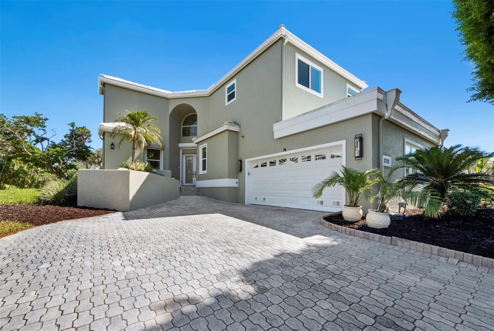 Elegant 5BR/5BA home in the gated community of Corey’s Landing within Bay Isles on Longboat Key. With over 4,500 sq ft, this spacious two-story residence offers open living areas, soaring ceilings, and refined design for both comfort and style. The light-filled great room with 22-ft ceilings opens to a gourmet kitchen with stone countertops, breakfast bar, and stainless-steel appliances. The main-level primary suite features pool access, dual vanities, soaking tub, and walk-in shower. A fifth bedroom or office, full bath, laundry room, and elevator complete the first floor. Upstairs includes three en-suite bedrooms, including a guest suite with private balcony and golf course and bay views. Outdoor living includes a screened lanai, heated pool and spa, and lush tropical landscaping. Updates include 2018 roof, new A/C (2023), tankless water heaters, and new pool/spa motors. Owners enjoy deeded beach access at the Bay Isles Beach Club plus community tennis, pool, spa, kayak launch, and 24-hour gated security. Close to the Longboat Key Club, offering world-class golf, tennis, marina facilities, dining, and a private Gulf-front beach experience, as well as the shops and restaurants of St. Armands Circle.