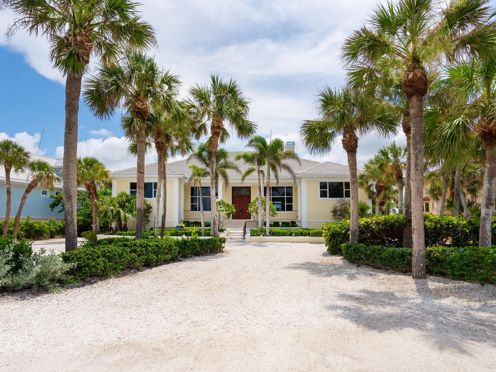 One or more photo(s) has been virtually staged. A waterfront paradise dream—an exquisite Gulf-to-Bay estate set on 1.4 tropical acres along the shores of Casey Key. This stunning two-story home, built in 1999, with solid concrete block construction on pilings, offers 4,460 sq ft under air (11,189 total sq ft), 5 bedrooms, and 4 and one half bathrooms, including a luxurious Owners’ Suite. Property highlights include an impressive 18-ft base flood elevation with impact windows on the Gulf front west side & retractable shutters on the east. Enjoy travertine and oak floors, soaring ceilings, and refined column millwork. The flexible layout provides plenty of room for family and guests alike, home office space, a cozy den and elevator shaft ready for convenience. Four-car side-entry garages, workshop plus extensive non-conforming storage below the main living area stayed dry and impervious to recent storms. An outdoor oasis lies between 150-ft of private sandy beach frontage with a grandfathered cabana and 150-ft bay frontage featuring a protected intracoastal boat basin set just beyond the pool and spa. Florida native plantings create a serene backdrop throughout the grounds. Wake to sparkling Gulf breezes, take private beach strolls, or dock your boat on the intracoastal basin. Host elegant gatherings throughout the open main living areas, enjoy casual living in the screened porch, or retreat to the secluded Owners’ Suite—this home blends relaxed coastal living in one of the most prime Gulf-to-Bay locations—luxury, privacy, and panoramic waterfront views on Casey Key await your personal touch and modern updates to make it your own.