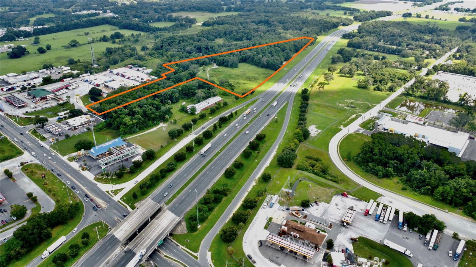 21.03 industrial/commercial acres located at one of the busiest semi-truck interchanges in the country along I-75 at the Hwy 326 interchange in Ocala, FL. Zoning provides an excellent location for many uses including: retail sales, warehouse/distribution, logistics, semi-truck parking, outside storage, etc. The property features HUGE visibility along I-75 with over 2,016'+/- of frontage. Currently, the property has 3 billboard signs generating income. Notable businesses in the area include NexTran Truck Centers, Ocala Freightliner, Pilot Travel Center, and Copart Auto Sales. Less than two miles south, Amazon, Chewy, Autozone, Fedex and Averitt Express have major logistics operations.