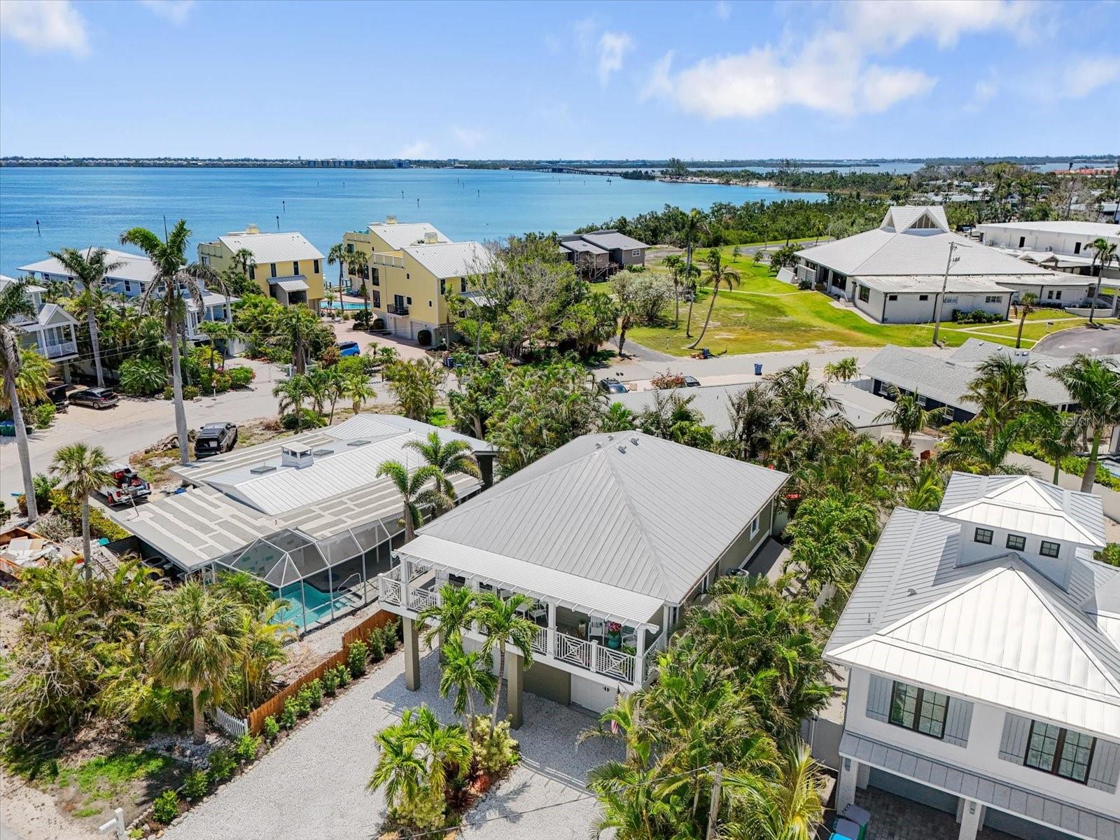 This is the one you have been searching for! Welcome to this charming, fully elevated Key West-style home featuring 3-bedrooms and 2-baths, all with breathtaking views of the Bay and the iconic Skyway Bridge. Located in the desirable Sportsman’s Harbor, you will have access to a community boat ramp shared by a select group of homes, where manatees and dolphins frequently gather, putting on a private show for residents! Step inside this meticulously maintained home, where an open floor plan awaits you, complete with vaulted ceilings, custom trim work, and wide plank wood floors. The spacious eat-in kitchen designed both for functionality and style, while the cozy cottage aesthetic reflects throughout, including a large comfortable living area, beautiful primary bedroom with private ensuite, and balcony, and two additional comfortable guest bedrooms. Venture outside to a serene “secret garden" covered balcony, the perfect spot to relax and soak in the stunning Bay views. For added convenience, you can take the elevator or staircase down to your private oasis backyard, designed for entertaining. Gather around the outdoor kitchen and bar, sheltered further by a generous retractable awning, ideal for alfresco dining. Surrounded by lush, mature landscaping and beautifully curated decor, your free-form saltwater pool and lounge areas create a tranquil retreat. Home sits atop a huge, well-appointed garage with ample storage, laundry and newly finished epoxy flooring and enough room to store all your water toys and vehicles! Just a short 5-minute stroll away, you will find access to one of the most beautiful beaches in the world and the captivating waters of the Gulf. Anna Maria Island is one of the most sought-after vacation destinations in Florida offering a vibrant culture with locally owned shops, wonderful restaurants, and the charm of a true small town Florida Beach community. This wonderful home, zoned for weekly rental, makes it an excellent investment property or a delightful second home. It comes turn-key furnished, excluding. personal items. Do not miss out- schedule your private showing today! Seller will provide a concession of $15,000 to the buyer for the absence of outdoor appliances and replace grill in the outdoor kitchen and bar area.