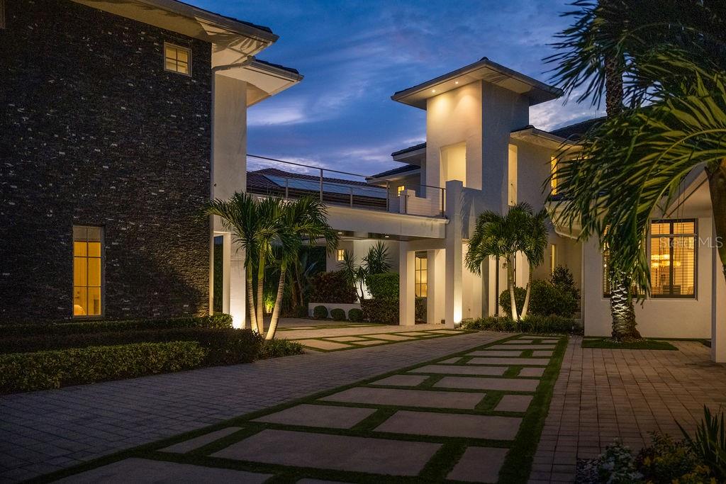 Welcome to a stunning professionally designed home nestled within the guard gates of Keenes Pointe in Windermere. This exceptional residence boasts 8,305 sq ft of luxurious living space, meticulously crafted with top finishes and elegant wood beams throughout. This home offers ample space and privacy for everyone with three rooms on the first floor, an additional bedroom upstairs, a master suite, a detached guest house, and a detached office. The master suite is a true retreat, featuring a separate living room, a private balcony with pond views, his and hers closets, a cozy fireplace, a breakfast area, and an extra-large linen closet. The heart of the home is the kitchen, a chef's dream with a large island and seating area, top-of-the-line appliances, and a spacious walk-in hidden pantry. The living area is beautifully appointed with porcelain tile, and the bar/game room offers real wood finishes and picturesque views of the pond. The gym on the first floor includes a sauna, perfect for relaxation and wellness. The open floor plan seamlessly connects the indoor and outdoor spaces, creating the perfect entertainment area with fully open sliding doors that invite you to enjoy the serene pond views. The home also includes a four-car garage (2/2), a convenient laundry room downstairs, and an elevator for easy access to all levels. For movie enthusiasts, there is a nine-seat movie theater with carpet flooring, providing a cozy and immersive experience. The home is equipped with five new AC units installed in 2023, anti-hurricane windows for added security, and a state-of-the-art ADT security system. The luxurious atmosphere is enhanced by the full surround sound system. The heated pool has been renovated, features a spa, seat in area, and new equipment installed in 2022. Additionally, the exterior of the home received a fresh paint job in 2023. Located within the sought after Keenes Pointe community, with a membership residents may access The Golden Bear Club, featuring a Jack Nicklaus Signature-designed course. This home is the epitome of luxury living, offering an unparalleled lifestyle in one of Windermere's most sought-after communities. Don’t miss the opportunity to make this exquisite residence your own. Contact us today to schedule a private tour and experience the elegance and sophistication of this remarkable home.