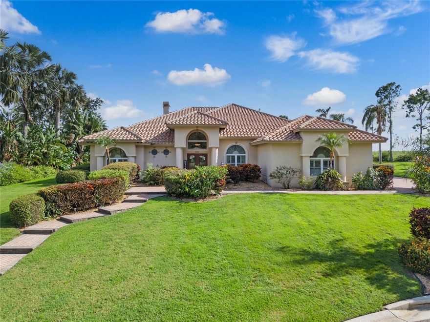 Gated custom home located within the peaceful and picturesque community of Heron Cay — welcome to 3211 Heron Cove. Nestled behind the private gates of this exclusive enclave of just 24 custom residences along the shores of Lake Eloise, this exceptional 4-bedroom, 3.5-bath pool estate offers 3,480 sq. ft. of refined living on a 0.66-acre cul-de-sac lot. Here, architectural elegance, luxurious finishes, and resort-style amenities come together to create a home that is as livable as it is impressive. From the moment you arrive, manicured landscaping, mature palms, and a stately façade establish a tone of quiet sophistication. Inside, the grand entry opens to rich bamboo and Italian travertine flooring, formal and casual living areas, and a thoughtful layout designed for both intimate gatherings and large-scale entertaining. The formal living room, anchored by a travertine-faced fireplace, makes an elegant centerpiece—perfect for celebrations or quiet evenings in. The open family room offers abundant natural light, built-in AV storage, and seamless access to the outdoors, ideal for relaxed living and movie nights. The kitchen is a showpiece with exotic granite countertops, a leathered-granite island, Sub-Zero 120-bottle two-zone wine refrigerator, professional-grade stainless appliances, natural gas range, hidden butler’s pantry, and a dedicated coffee station. Nearby, an entertainer’s bar invites you to craft cocktails or frozen daiquiris to enjoy by the pool. The primary suite is a serene retreat with a spa-inspired bath featuring an oversized walk-in shower with body sprayers, separate steam shower, expansive granite-topped vanity, dedicated makeup area, and a massive walk-in closet. Bedrooms two and three each have en-suite baths and walk-in closets, while bedroom four offers versatility as a gym, media room, or office. Outdoor living is equally refined with hammered marble decking, heated pool and spa, covered and open lounge areas, and a pavered sitting space surrounded by lush landscaping for total privacy. Additional highlights include a whole-house generator, comprehensive water-filtration system, tile roof, impact-rated doors, insulated windows, plantation shutters, a 3-car garage with abundant storage, and irrigation well. Beyond the gates, Heron Cay offers privacy and connection to the best of Winter Haven living. Lake Eloise—part of the renowned Winter Haven Chain of Lakes—provides boating access to 20+ interconnected lakes, waterfront restaurants, and spectacular LEGOLAND fireworks over the water. Centrally located, Winter Haven blends small-town charm with modern convenience, boutique shopping, fine dining, theatre, cultural events, golf, parks, and nature trails. With its prime location between Tampa and Orlando, this residence offers an unmatched lifestyle defined by elegance, comfort, and timeless Florida living.