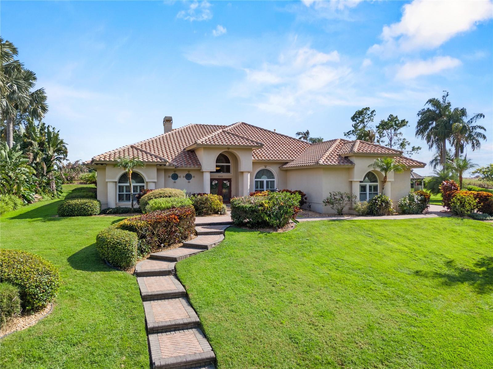 Tucked within the private gates of Heron Cay...an exclusive enclave of just 24 custom residences nestled along the shores of picturesque Lake Eloise...this extraordinary 4-bedroom, 3.5-bath pool estate offers 3,480 sq. ft. of refined living on a 0.66-acre cul-de-sac lot. Here, architectural elegance, luxurious finishes, and resort-style amenities come together to create a home that is as livable as it is impressive.
From the moment you arrive, the manicured landscaping, mature palms, and stately façade set a tone of quiet sophistication. Step inside the grand entry to find rich bamboo and Italian travertine flooring, formal and relaxed living spaces, and a thoughtfully designed layout tailored for both large-scale entertaining and intimate gatherings. The formal living room, anchored by a travertine-faced fireplace, makes an elegant centerpiece—perfect for special celebrations or quiet evenings in. The wide-open family room offers built-in discrete AV storage, abundant natural light, and easy access to the outdoors, creating the ideal setting for enjoying movie nights and watching weekend sports.
The kitchen is nothing short of spectacular, featuring exotic granite countertops, a leathered-granite island, Sub-Zero 120 bottle two-zone wine refrigerator, professional-grade stainless appliances, a natural gas range, hidden butler’s pantry, and a dedicated coffee station. Just steps away, an entertainer’s bar is perfectly positioned for crafting cocktails or frozen daiquiris to enjoy poolside.
The primary suite is a serene retreat with generous proportions and a spa-inspired bath complete with an oversized walk-in shower with body sprayers, separate steam shower, expansive granite-topped vanity, a dedicated makeup area, and a huge walk-in closet. Bedrooms two and three each feature en-suite baths and walk-in closets, while the fourth bedroom offers flexibility as a gym, media room, or executive office.
The outdoor living is equally refined with hammered marble decking, a heated pool and spa, covered and open lounge spaces, and a pavered sitting area—all surrounded by lush landscaping for the ultimate in seclusion and privacy. Additional upgrades include a whole-house generator for peace of mind, a comprehensive water-filtration system, a tile roof, impact-rated doors, insulated windows, plantation shutters, a 3-car garage with abundant storage, irrigation well, and more.
Beyond the gates, Heron Cay offers a lifestyle that is both private and connected. Lake Eloise is part of the world-famous Winter Haven Chain of Lakes, a boater’s paradise with access to 20+ lakes, waterfront restaurants, and spectacular LEGOLAND fireworks over the water. Winter Haven itself blends small-town charm with modern convenience—home to boutique shopping, fine dining, cultural events like Theatre Winter Haven and the annual Chain of Lakes Boat Parade, as well as outdoor activities including golf, parks, and nature trails. Just minutes away are major medical facilities, while Tampa and Orlando (with international airports, professional sports, and world-class attractions) are an easy drive in either direction.
Offering the prestige of a gated lakefront community, the serenity of a private setting, and the convenience of Central Florida’s premier location, this home is a rare opportunity for those who demand excellence, privacy, and an uncompromising standard of living.