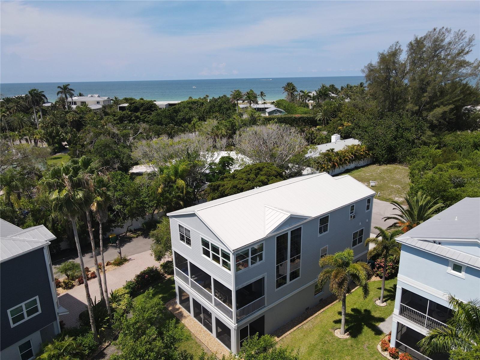 Motivated Seller! Bring offers! Live the ultimate Beach lifestyle! This Raised (16ft.)Hurricane ready three bedroom(Possible 4Th) three bath, three car garage home is situated perfectly between the gulf and bay. 2024 weather events proved benign for this sturdy home. Enjoy your deeded beach across the street and a private boat dock on Sarasota bay. The exclusive, gated community of Laguna Yacht Village is Longboat Key's best kept secret, consisting of only 8 homes on 9 lots. This quiet, private beach/ boating development is unmatched! The home has been thoroughly modernized and expanded in 2019/2020 by the current owners. New 25 year aluminum roof, pre-painted hardiplank exterior, enclosed upper deck expanded Master Suite, complete bathroom and kitchen renovations, new water heater, air conditioner, washer dryer and kitchen appliances (Sub Zero and Bosch) as well as refinished hardwood floors on the main level and newly laid matching hardwood floors throughout the entire upstairs make this effectively a totally new home. Whilst not required by the current owners, the upstairs loft area could easily be converted into a 4th bedroom. The majority of the work was accomplished by Greyhawk of Bradenton. Other lavish touches include new solid panel doors, new 16 feet wide opening glass slider doors, integrated 180 bottle wine fridge, an oversized 3 car+ garage including new door and the installation of a 10,000 lb boat lift at the deeded private dock. Call today to schedule your private Viewing.
