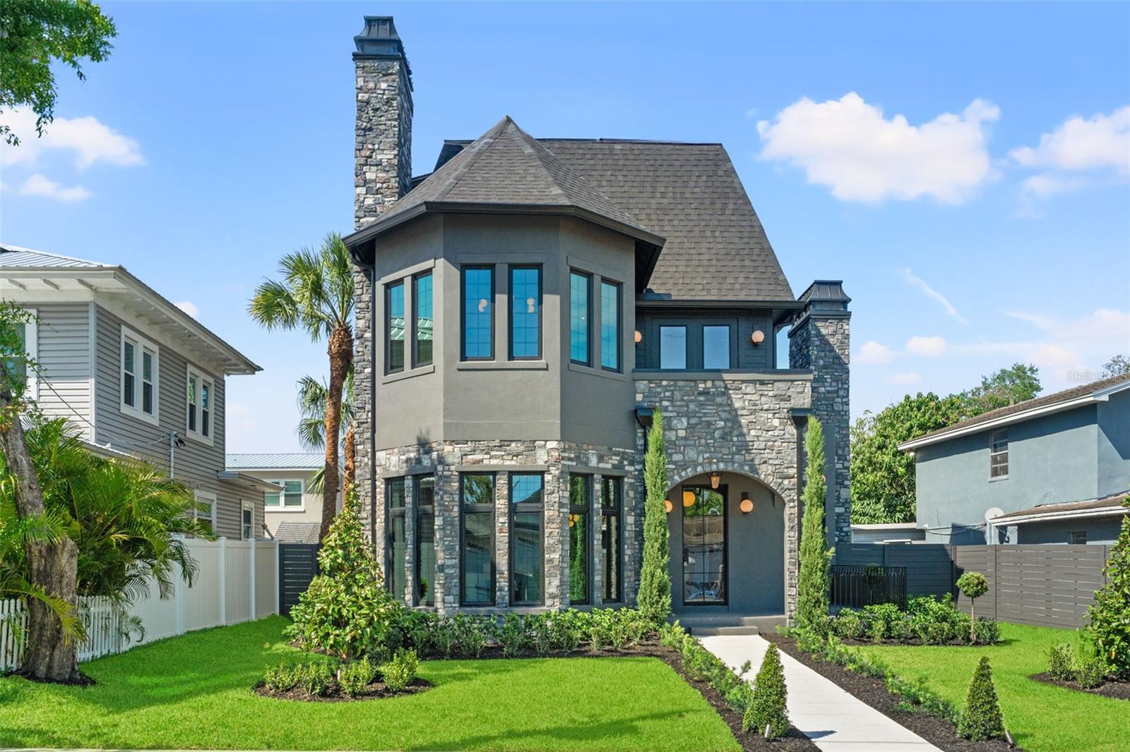 BUILDER INCENTIVES OFFERED! As seen on HGTV's 100 Day Dream Home! Welcome to 807 W Park Ave, a one-of-a-kind residence built by VIKIN Homes in the heart of Ridgewood Park—where timeless Gothic Revival architecture meets modern luxury. This brand-new, meticulously crafted 5-bedroom, 5.5-bathroom home offers an extraordinary blend of classic design elements and cutting-edge finishes, creating a living experience unlike any other. This stunner boasts five spacious ensuite bedrooms with custom walk-in closets across three floors. Floor one is adorned with mostly common space including your two-toned designer kitchen, dining room, living room, fully built out pantry and built-in mudroom. Floor two is where you go to rest and reset by way of the primary and two separate auxiliary bedrooms. Floor three wraps’ things up by offering more sanctuary with two additional bedrooms and an oversized flex room that hosts ample cabinet and countertop space along with refrigeration. Whether you utilize it as a media room, game room or children’s playroom, its location on the third floor will ensure its occupants aren’t disturbing anyone else in the home. Enjoy panoramic views of downtown Tampa and the Ridgewood Park Butterfly Garden from your private balcony—perfect for morning coffee or evening sunsets. Location is prime being just one block away from the beautiful Hillsborough River and the vibrant Armature Works property, offering access to Tampa's finest dining, shopping, and cultural attractions. This home blends the grandeur and charm of Gothic Revival design with modern, high-end amenities. With its towering spires, arched windows, intricate stonework, and high ceilings, it’s a rare find in the dynamic Ridgewood Park neighborhood. This is more than a home….it’s a lifestyle.