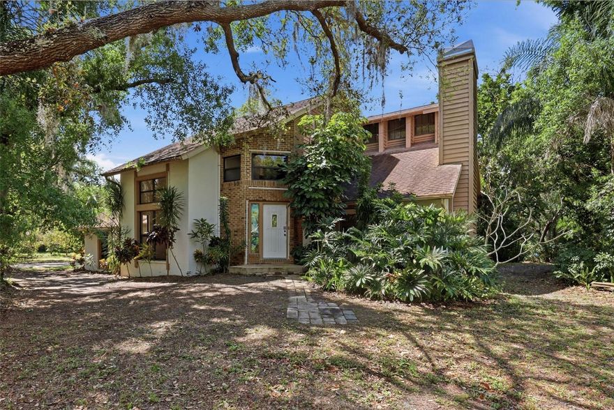 Tucked away off Clark Road in Sarasota, this extraordinary property is more than a home, it’s a private sanctuary for those who value space, serenity, and possibility. Set on just over six lush acres with a winding, tree-lined driveway, the experience begins the moment you arrive.
With over 400 mature trees, this one-of-a-kind place feels like your own botanical retreat. A rich variety of avocado, mango, eucalyptus, jacaranda, macadamia, lychee, starfruit, jackfruit, and Thai jujube trees create a vibrant, ever-changing landscape filled with color, texture, and life. This setting is both inspiring and rare. In the southwest corner of the property lies a picturesque one-acre private lake, offering tranquil water views and a sense of calm that’s hard to find. The expansive grounds, zoned 2-acre Open Use Estate, provide incredible flexibility for those seeking a private retreat, a multi-use property, or simply room to breathe and grow. The two-story residence is light and bright, blending indoor and outdoor living seamlessly. Strategically placed windows invite natural light to pour in while capturing beautiful views of the surrounding landscape from nearly every room. The result is a home that feels open, airy, and deeply connected to its environment. Every corner of this property has been designed to embrace the outdoors and enhance the sense of privacy and escape. One of the most compelling aspects of this offering is the freedom it provides. With no deed restrictions, no CDD fees, and no homeowners association, you have the flexibility to truly make this property your own. Bring your RV, boat, trailers, and toys—there’s ample space and no limitations holding you back. Properties like this are exceptionally rare in Sarasota—a peaceful, private oasis with acreage, natural beauty, and unlimited potential, all within reach of the area’s renowned amenities, beaches, and lifestyle. This is not just a place to live—it’s a place to create, to unwind, and to experience Florida in its most authentic and inspiring form. As Mark Twain once said, “Buy land, they're not making it anymore.”