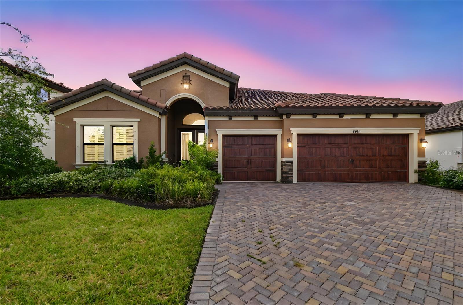 Step into luxury with this stunning Bayshore 1 floor plan—one of Homes by West Bay’s most sought-after designs. Nestled on a serene conservation lot, this beautifully upgraded home offers four spacious bedrooms, three full bathrooms, and a dedicated office space. From the moment you enter through the grand double foyer, you’ll be impressed by the soaring ceilings, elegant shutters, and impeccable custom touches throughout. At the heart of the home is the gourmet kitchen—a chef’s dream—featuring a farmhouse sink, built-in appliances, a five-burner gas cooktop, and a striking custom wood vent hood. White cabinetry, quartz countertops, a charming brick backsplash, and a reverse osmosis water system further elevate the space. The extended island not only enhances the kitchen’s aesthetics but also offers additional seating for casual dining. The expansive grand room is the centerpiece of this home, showcasing a stunning brick fireplace with built-in custom cabinetry. Paired with the adjacent dining area, this open-concept space is perfect for entertaining. The private office is filled with natural light and features elegant double doors—ideal for remote work or as a cozy secondary living area. The thoughtful three-way split floor plan offers privacy and flexibility. The luxurious primary suite boasts oversized his-and-hers walk-in closets and a spa-like en-suite bathroom complete with a soaking tub, walk-in shower, and dual quartz vanities. Two additional bedrooms at the front of the home share
a stylish full bathroom and feature custom built-in raised beds, while the fourth bedroom enjoys its own private bath—perfect for guests.
Practicality meets charm in the extended laundry room and drop zone, which includes a sink, storage cabinets, and floating shelves. Additional upgrades include a tankless gas water heater, reverse osmosis system, water softener, and newly installed solar panels—ideal for energy-conscious living.
