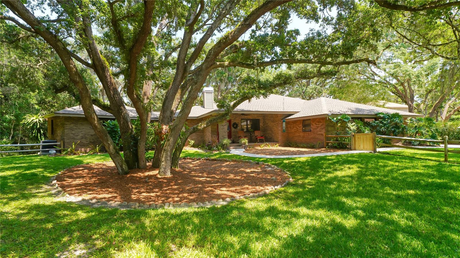 Tucked away on a very private lot, under a canopy of stately oaks, this gorgeous home in Foxfire West nestled on over two beautifully landscaped acres. The exterior construction of rustic brick over block blends gracefully into the wooded background and you will feel away from it all, but only a short drive to shopping, dining, and I-75. The current owners have lovingly cared for this home and made numerous improvements throughout, including a brand new kitchen. A double sided fireplace of natural coral stone shines its glow in both the formal living room and family room. The master suite features three sets of well-placed windows designed to bring the beauty of nature indoors. The open kitchen features a floating island and adjoins the dining area. The master bath is stylish with a glass block walk-in shower with 2 heads and a relaxing Jacuzzi tub. The second bedroom can also be a master with bathroom and new expansive walk-in-closet. Outdoor entertaining a must with a covered and screened 11 x 27 ft lanai and a composite wood deck with built-in brick BBQ. A garage workshop and storage shed come in handy and so does the 35 x 42 ft. parking space for boats or trailers. This home is extremely private and can not be seen from Hoyer Drive. New roof 2018, New Kitchen Appliances 2018, New Kitchen 2022, New Washer & Dryer 2020, New A/C 2020, New H.W.H. 2020. Owners in Foxfire West have access to Freshwater Lake, Foxfire access on Hubner drive. Total of 8 parking spaces. Shopping & Medical offices within a 5 miles drive. Seller to pay Title Insurance.