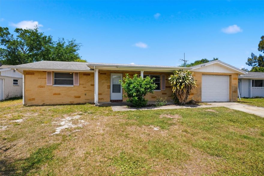 Opportunity awaits with this 3-bedroom, 2-bath single-family home with an attached garage, ideally located east of US Hwy 19. Situated in an X flood zone, this property offers added peace of mind and strong long-term investment potential.

Inside, you’ll find a functional split-bedroom floor plan with great natural light throughout and solid bones ready for your vision. The layout offers flexibility for updates, while the screened-in back porch provides a great starting point for creating an inviting outdoor living space overlooking the backyard.

Recent big-ticket improvements, including a new AC (2024) and flat roof (2023), help minimize upfront costs and improvements.