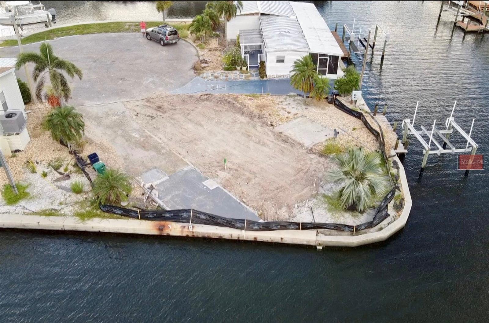 NEW PRICE - PRIME WATERFRONT OPPORTUNITY – YOUR BLANK CANVAS AWAITS in TROPIC ISLES, a 55+ RESIDENT OWNED WATERFRONT community. Seize this rare opportunity to create your dream home on an exclusive waterfront lot, offering a spectacular setting and unbeatable location. LOCATION, LOCATION, LOCATION! This CUL-DE-SAC WATERFRONT LOT holds endless potential for transformation. Imagine designing your perfect oasis with stunning water views, where the sunlight dances across your patio, and graceful egrets & spoonbills fly by at sunset, adding a touch of nature’s magic to every evening. VACANT LOT/SHARE comes with DOCK & 8,000 LBS BOAT LIFT.