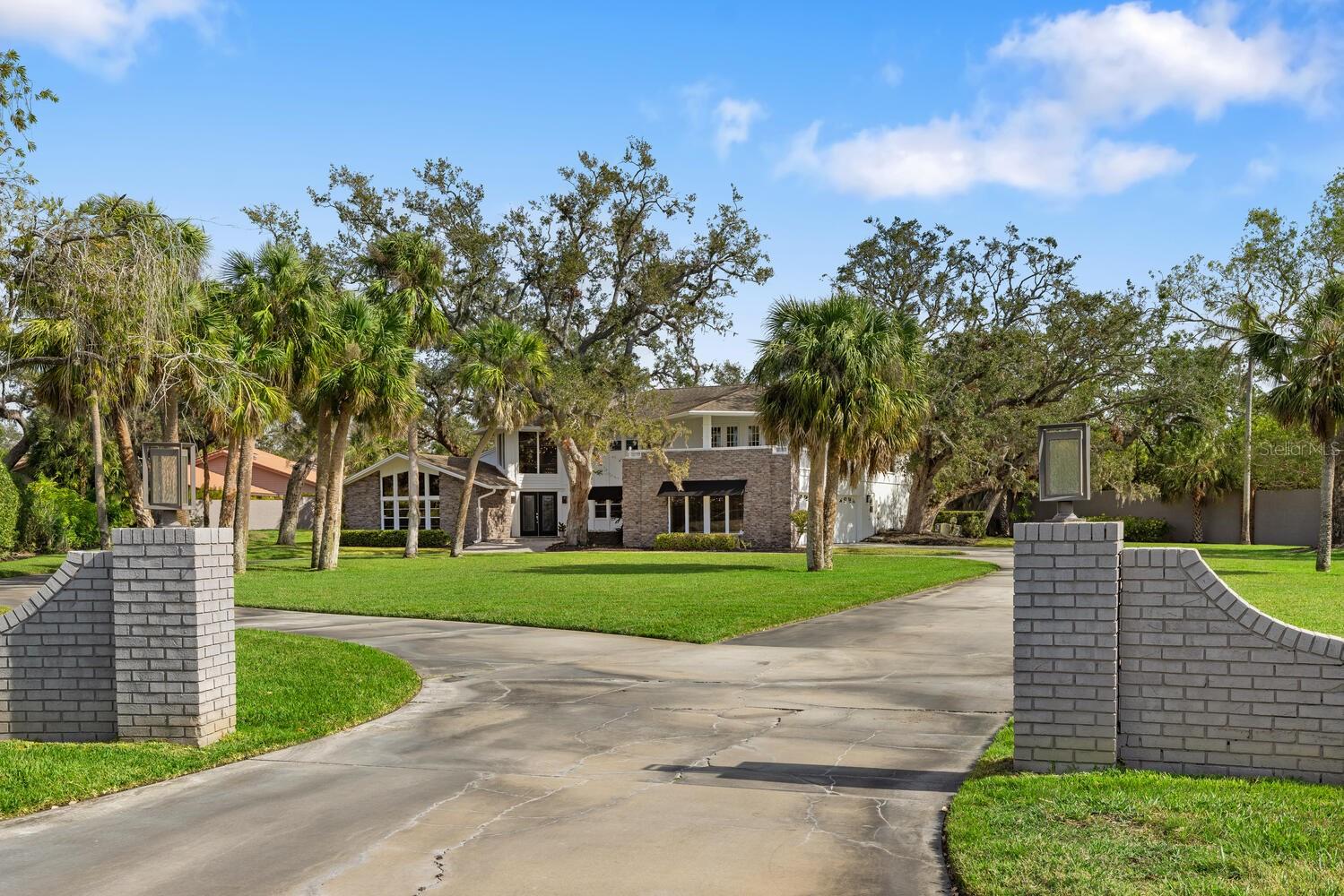 Nestled on over an acre in the exclusive, gated community of Beneva Oaks, this stunning 5,200-square-foot residence offers privacy, luxury, and a prime Sarasota location. Lovingly maintained by its current owners, this two-story home blends timeless elegance with modern updates. A grand entrance welcomes you into the foyer, where a graceful spiral staircase sets the tone for the living spaces beyond. The expansive dining room is perfect for hosting, while the spacious kitchen – complete with a eat-in area – overlooks the lush, private backyard. The first floor boasts a fabulous primary suite with an adjoining den, providing for a peaceful retreat. Upstairs, four additional bedrooms, two full baths, and a versatile flex space offer endless possibilities. Three of the bedrooms open onto a screened balcony, while an additional open balcony invites you to relax and take in the sunset. Designed for entertaining, the screened-in patio extends your living space outdoors, featuring a saltwater pool and plenty of room to enjoy Florida’s year-round sunshine. This home also includes a three-car side-entry garage and sits at the end of a cul-de-sac offering privacy. Over the years, thoughtful improvements have enhanced this exceptional property, including new flooring throughout, updated bathrooms, newer air conditioning units, a remodeled pool and lanai, Trex decking, a refreshed front entry, and a newly replaced septic system. Located just minutes from everyday conveniences, top-rated schools, and a short drive to Sarasota’s Siesta Key beach and vibrant downtown, this home is a rare opportunity in one of the area’s most sought-after neighborhoods.