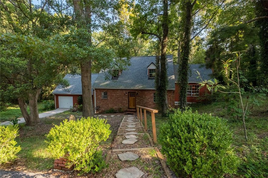 !!MOTIVATED SELLER!! Discover modern charm in this beautiful split-level home, nestled in woodlands on a half-acre lot bordering Hogtown Creek. A spiral staircase leads you to two upper-level bedrooms and a bathroom, and the master on the ground level. The living room features a vaulted ceiling with exposed heart-of-pine beams and a classic fireplace. Enjoy serene creek views from the screened-in porch, and entertain in the backyard gathered around the fire pit. The treehouse and basketball court provide plenty of room for play. This property merges timeless design with contemporary amenities for a wonderful home. Unique house that would make your perfect new home or a great short term rental location. Come check it out right away!