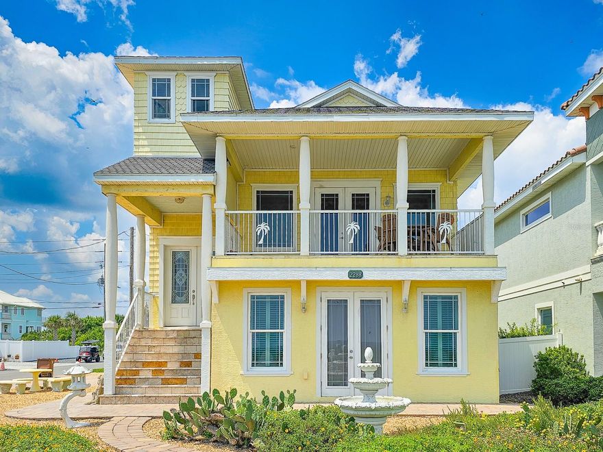 OCEANFRONT FLAGLER BEACH HOME with Littoral Rights. and a 1st rate separate guest suite with a 3.5 car garage!  Absolutely stunning views with beach access virtually steps away. This well-built 2014 home sits proudly on a rare corner lot. Florida native landscaping beds nestled in pebble stone and a paved cobblestone drive and walk-ways make yard maintenance a breeze.  Enter through the lovely leaded glass French doors to the second floor, main living space of this home. You can also access your home from a side door or from inside the garage. Natural light floods into the open floorplan with high ceilings and beautiful travertine flooring. Step out onto the covered balcony for panoramic views of the ocean and the soothing sound of the waves and whale watching. The kitchen and baths showcase deluxe, soft-close hardwood cabinetry and granite countertops. While entertaining and preparing lovely meals you will see that ocean views are abundant. Moonrises on the ocean are something to behold. The primary bedroom is enhanced by an en-suite bath with a large linen closet. Laundry hook-ups are conveniently located in a separate primary bedroom closet that will accommodate a full-size stackable washer and dryer. The second bedroom on the main living space is charmingly accessed by a spiral staircase and affords bird’s eye views of the beach. The spacious 854 square foot suite on the ground level will accommodate additional family, visitors and guests. The beautiful suite has its own kitchen, dining and living space, with a private entrance, one bedroom and a full bath, also features glass French doors opening to a patio just steps from the beach. This suite has great ocean views as well. A 2-door, 3.5 car side entrance garage with Raynor doors and a half bath completes this magnificent home. Premium 50-year shingle roofing, premium 50-year vinyl siding, radiant heat barrier system, a new Carrier HVAC system and PGT hurricane impact windows and door glass provide security and comfort. Perfectly situated to take advantage of all that Flagler Beach has to offer, the location has easy access to local restaurants, boutique shops, and the Flagler Beach Pier. For outdoor enthusiasts, there are scenic biking and walking trails, world-class fishing, boating, and kayaking opportunities nearby. Flagler Beach is located just 3 miles east of I-95, between St. Augustine and Daytona Beach, offering endless dining, entertainment, and cultural experiences. Schedule your private tour today and start living the coastal dream in this prime location!