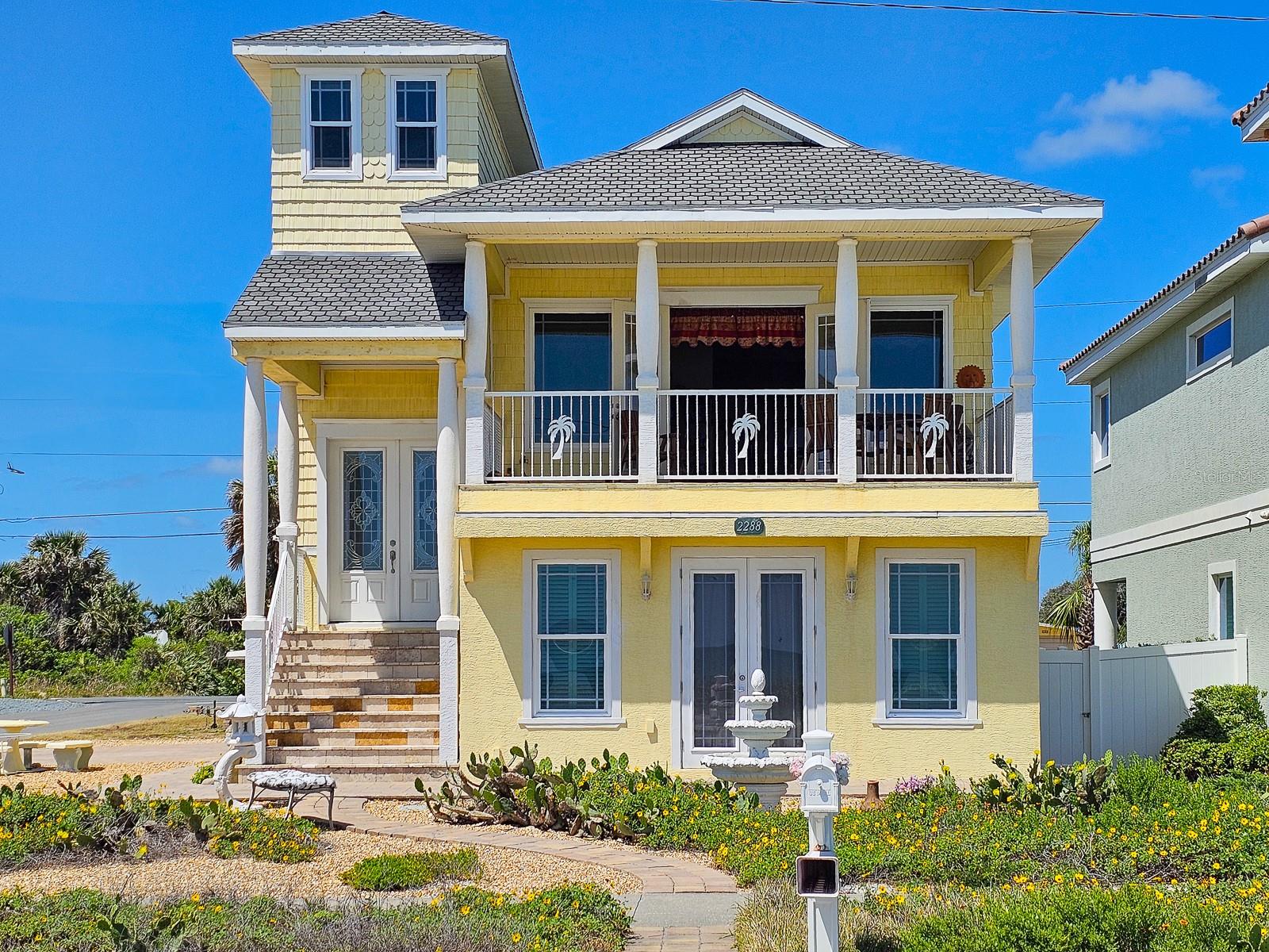 OCEANFRONT FLAGLER BEACH HOME with Littoral Rights. and a 1st rate separate guest suite with a 3.5 car garage! Absolutely stunning views with beach access virtually steps away. This well-built 2014 home sits proudly on a rare corner lot. Florida native landscaping beds nestled in pebble stone and a paved cobblestone drive and walk-ways make yard maintenance a breeze. Enter through the lovely leaded glass French doors to the second floor, main living space of this home. You can also access your home from a side door or from inside the garage. Natural light floods into the open floorplan with high ceilings and beautiful travertine flooring. Step out onto the covered balcony for panoramic views of the ocean and the soothing sound of the waves and whale watching. The kitchen and baths showcase deluxe, soft-close hardwood cabinetry and granite countertops. While entertaining and preparing lovely meals you will see that ocean views are abundant. Moonrises on the ocean are something to behold. The primary bedroom is enhanced by an en-suite bath with a large linen closet. Laundry hook-ups are conveniently located in a separate primary bedroom closet that will accommodate a full-size stackable washer and dryer. The second bedroom on the main living space is charmingly accessed by a spiral staircase and affords bird’s eye views of the beach. The spacious 854 square foot suite on the ground level will accommodate additional family, visitors and guests. The beautiful suite has its own kitchen, dining and living space, with a private entrance, one bedroom and a full bath, also features glass French doors opening to a patio just steps from the beach. This suite has great ocean views as well. A 2-door, 3.5 car side entrance garage with Raynor doors and a half bath completes this magnificent home. Premium 50-year shingle roofing, premium 50-year vinyl siding, radiant heat barrier system, a new Carrier HVAC system and PGT hurricane impact windows and door glass provide security and comfort. Perfectly situated to take advantage of all that Flagler Beach has to offer, the location has easy access to local restaurants, boutique shops, and the Flagler Beach Pier. For outdoor enthusiasts, there are scenic biking and walking trails, world-class fishing, boating, and kayaking opportunities nearby. Flagler Beach is located just 3 miles east of I-95, between St. Augustine and Daytona Beach, offering endless dining, entertainment, and cultural experiences. Schedule your private tour today and start living the coastal dream in this prime location!