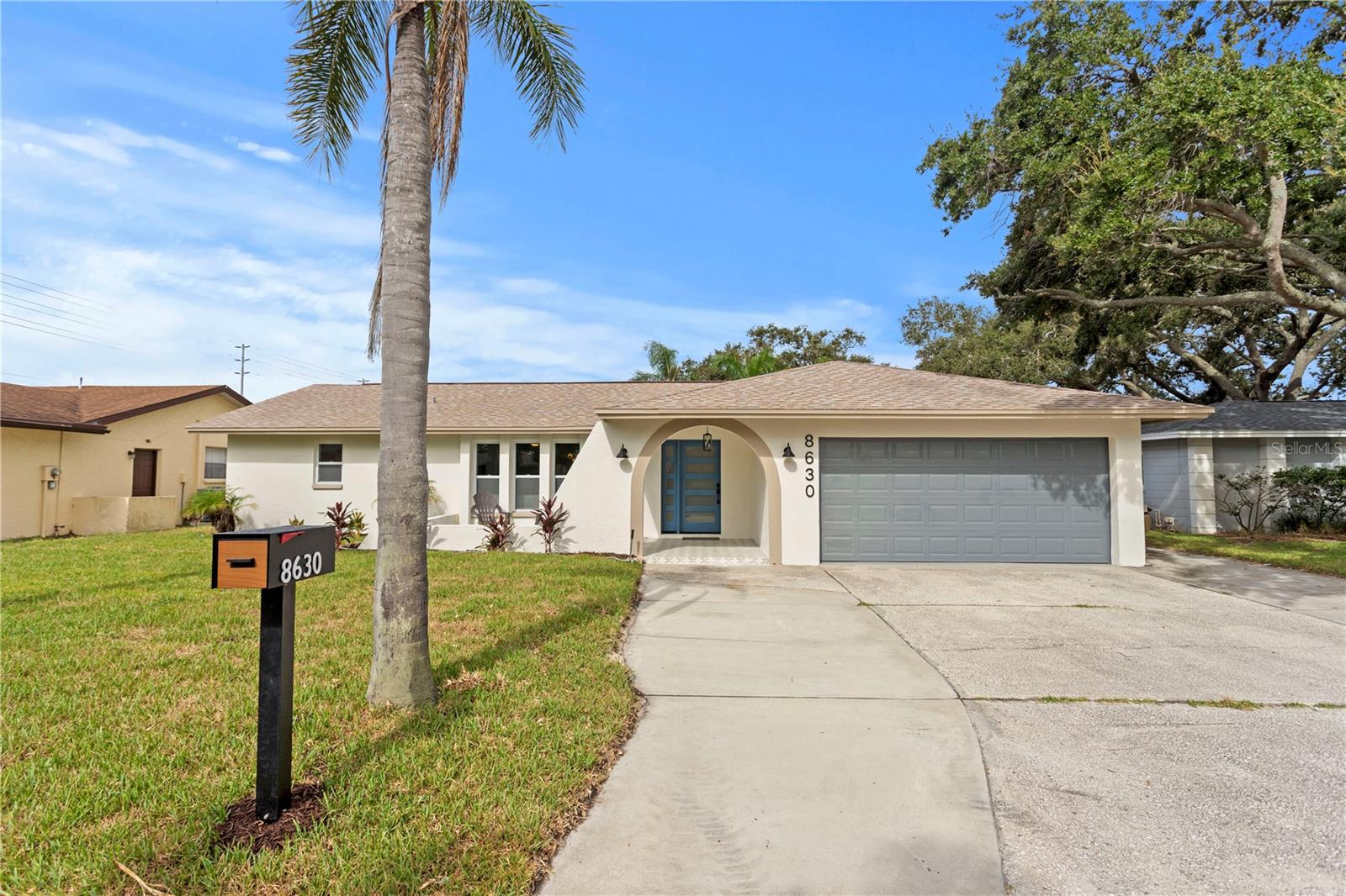 This bright and modern 3 bedroom, 2 bathroom pool home has been stunningly remodeled and has a spacious open floor plan perfect for living and entertaining. This home has all the curb appeal with a charming archway entry and front porch. The living room and dining room stream in natural light and are open to the kitchen, which was designed with style and function in mind with gorgeous forest green and white shaker cabinetry, quartz counters, marble backsplash, all new appliances and a center island. The family room off the kitchen has a cozy wood burning fireplace and vaulted ceiling. The primary bedroom has a walk-in closet and large en-suite bathroom with a stylish double vanity and tiled shower with two shower heads. Two secondary bedrooms are each a roomy 13x11 and share a full bathroom with a new tiled shower with tub. A covered and screened lanai can be accessed from sliders off the dining room, family room and primary bedroom. The fully fenced yard has an in-ground pool with an all new paver pool deck and another crushed shell patio. Other features include new luxury vinyl plank flooring in the main living areas and designer carpet in the bedrooms, newer HVAC (2024) and water heater (2023), a laundry room with utility sink and all new designer light fixtures. This home is not in a flood zone and is located less than a mile to local schools and is in convenient proximity to local beaches, 100-acre Walsingham Park, restaurants, shopping and more.