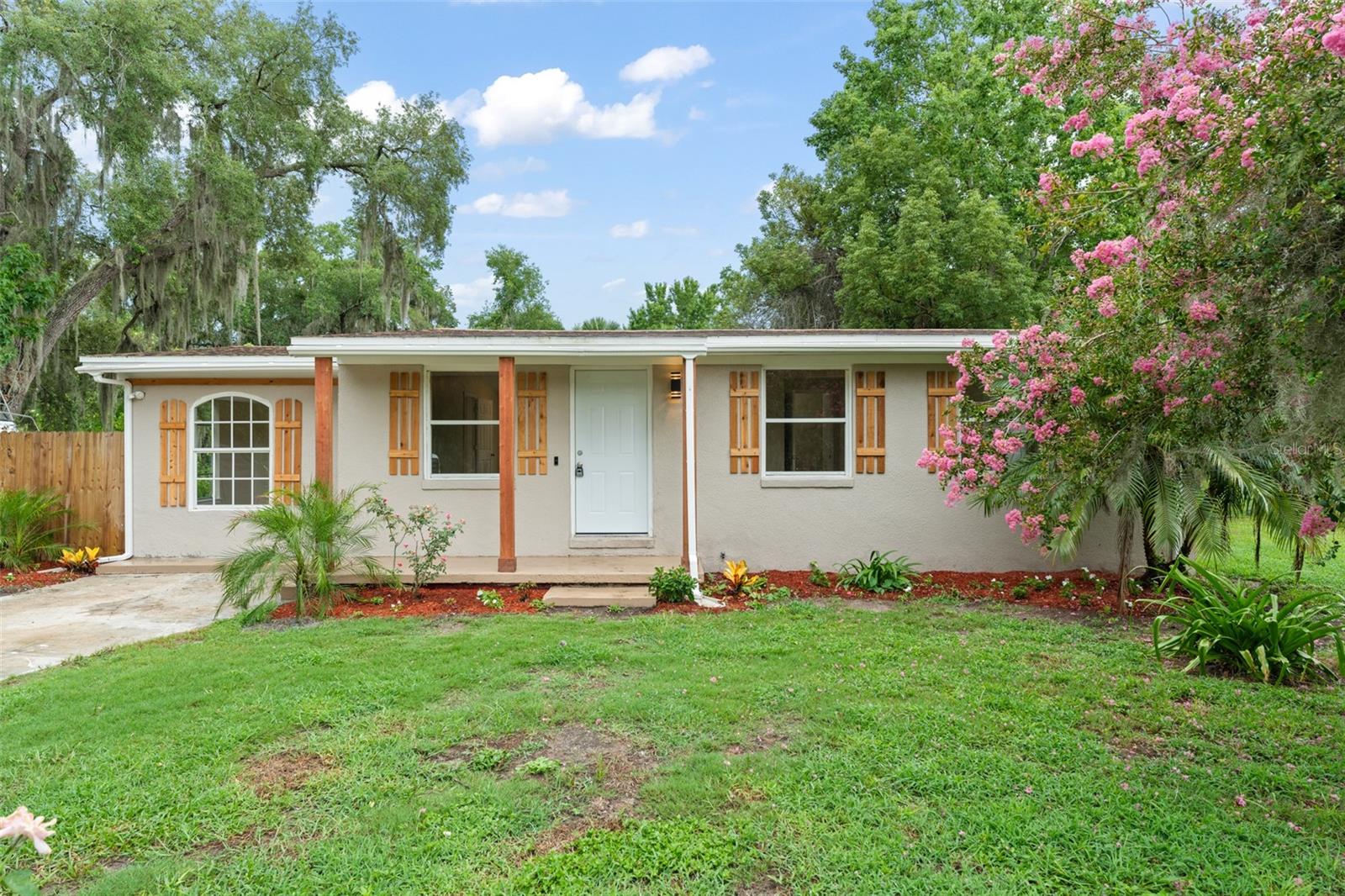 **This property qualifies for a closing cost credit up to $4,400 through the Seller’s preferred lender.** Welcome to 247 Toms Rd – A Cozy Retreat in the Heart of DeBary. Tucked away on a peaceful, 0.30-acre lot with no HOA, this charming 3-bedroom, 3-bathroom home is full of warmth, character, and quiet comfort. As you drive up the paved driveway, you're greeted by the home's welcoming presence—wood-toned pillars on the covered entry and matching faux wood shutters, all surrounded by subtle, thoughtfully maintained landscaping that sets a peaceful tone. Step inside and you'll find a galley-style living and kitchen area, enhanced by a vaulted ceiling and durable laminate flooring throughout. The layout is cozy yet open, with a kitchen pass-through window connecting the spaces and inviting conversation. The kitchen itself is light and bright, featuring white cabinetry, stone countertops, stainless steel appliances, and a sliding glass door that opens up to views of the private, grassy backyard. Just off the kitchen, you'll find an amazing bedroom complete with its own ensuite bathroom, built-in closet, and private exterior access to the side yard. It’s perfect for guests, extended family, or even a private workspace. The home’s split-bedroom layout provides privacy for the primary suite, located on the opposite side. This tranquil retreat features a large built-in closet and an ensuite bath with floor-to-ceiling tiled shower and crisp white vanity. The third bedroom, also with a built-in closet, is served by a stylish third bathroom just outside the door, complete with a tub/shower combo, vessel sink, and stone countertops that echo the kitchen’s elegant finishes. Step out back to discover a paved patio area and an inviting grassy backyard framed by mature trees and natural vegetation that offer both beauty and privacy. It’s a blank canvas waiting for your personal touch—whether it’s a garden, a firepit, or space for pets and play. This is more than just a house—it’s a place where memories are made, and life feels just a little bit quieter, warmer, and more connected.