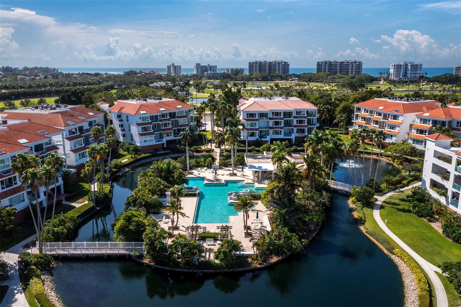 PENTHOUSE. Delight in scenic views of Sarasota Bay in this custom-designed, rare 4 bedroom, 4.5 bathroom in the gated resort-style Tangerine Bay community on the southernmost tip of Longboat Key. The residence is only minutes from St. Armand's Circle, across the street from the Longboat Key Club, and a short driving distance to the Bay Isles Beach Club and vibrant downtown Sarasota. Filled with abundant natural light, the spacious condominium features soaring ceilings, a great room with gas fireplace, marble foyer and gallery for displaying artwork, and private gated courtyard. All bedrooms are ensuite. New sliding glass doors in the primary suite and new glass window in the great room open to a tiled terrace where you can start your day with a cup of coffee while watching the sunrise over the lagoon and Bay. An additional west-facing terrace upstairs boats golf course and sunset views. The well-equipped kitchen includes stone counters, breakfast bar, large pantry and morning room. There is also a fully enclosed two-car garage with plenty of storage space as well as two AC units in the condominium. The Tangerine Bay Club community boasts beautifully manicured walking paths, amid newly planted tropical greenery as well as many amenities, including a pool with waterfalls, fitness center, a tennis/pickleball court, plus a day boat dock and fishing pier on the Bay. Residents have the option of joining the Beach Club (normally reserved for only Bay Isles residents) on the Gulf of America.