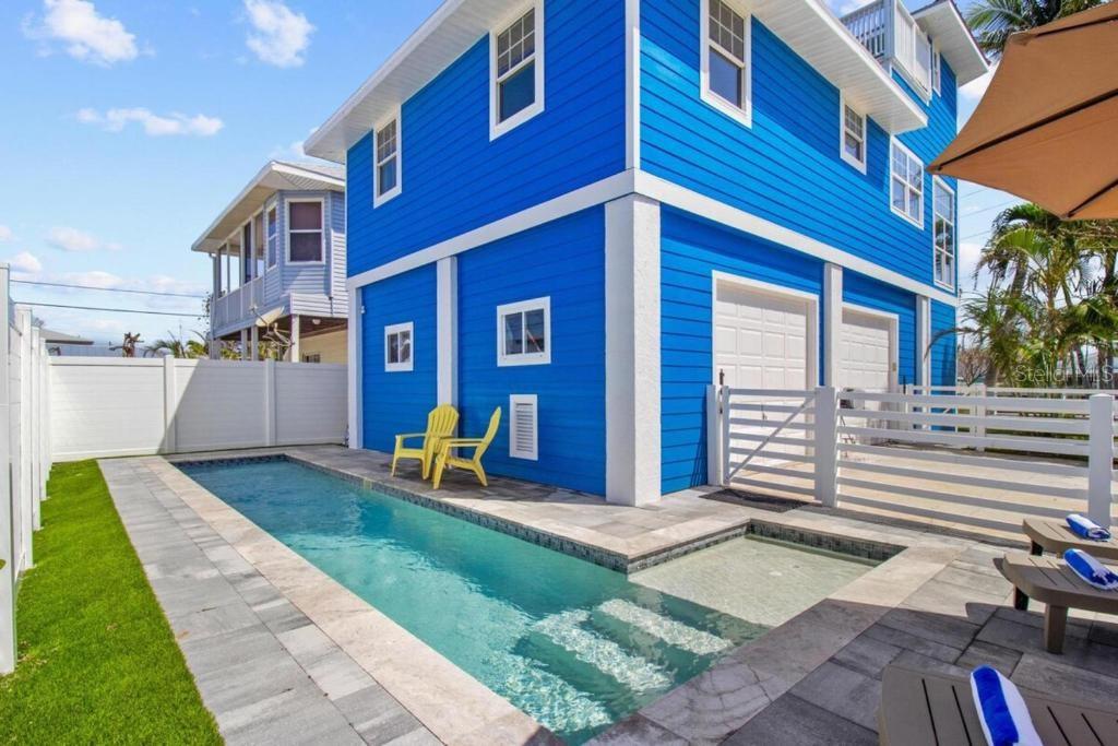 Live the ultimate coastal lifestyle just one block from the Gulf of Mexico in this beautifully unique 3-bedroom, 3-bathroom beachside home in the heart of Madeira Beach. Offering 1,772 square feet of bright (unfurnished), open living space, this multi-level property is designed for comfort, flexibility, and beachside enjoyment. On the ground level, a versatile bonus room makes the perfect home office, yoga studio, or fitness space. Upstairs, the main living area features vaulted ceilings, expansive windows that bring in natural light, and an airy open layout that includes a family room with a cozy wood-burning fireplace, a bright kitchen with a new gas stove, Bosch dishwasher, and island seating, plus two full bathrooms. Step onto the balcony to enjoy peaceful water views and fresh Gulf breezes. The private third-floor primary suite offers access to a spacious balcony with stunning intercoastal views and peek-a-boo sights of the Gulf of Mexico—perfect for relaxing evenings or morning coffee. Residents and guests can enjoy the year-round outdoor swimming pool, garden space, and a sunny terrace complete with an outdoor fireplace and seating area. (Garage's do not convey) Ideally located just minutes from John’s Pass Village, shops, dining, and boating activities, and only 14 miles from St. Pete-Clearwater International Airport. This is more than a rental—it’s your own beachside retreat with space to live, work, and relax by the sea.