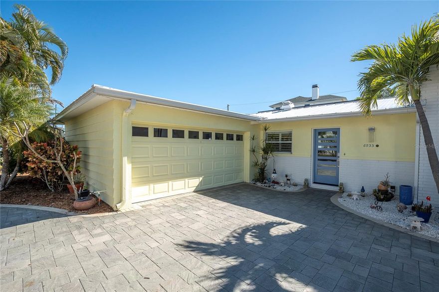 Pasadena Isle home with timeless design! This midcentury modern home has been thoughtfully renovated and offers a rare blend of architectural refinement, relaxed Key West vibe, and exceptional outdoor space. Mature palms, paver drive, clean lines, and low-maintenance tropical landscaping create an inviting first impression that feels both polished and welcoming. 
On the quiet island of Pasadena Isle, this fabulous three-bedroom, two-bath residence offers 1,592 square feet of inspired living space, brimming with original charm and thoughtful updates. Step through the inviting front courtyard and into a home that perfectly blends classic design with modern comfort. 
This home is equipped with a top-of-the-line 10kW solar panel system by Solar Source, which is owned outright. The system produces enough energy that the current owners only pay the required minimum fee to the electric company, making this residence extremely efficient and cost-effective to operate. Both the solar and roof warranties are transferable, offering added peace of mind for the next homeowner. The high-quality GulfLok Standing Seam aluminum roof was installed in 2020, providing durability and enhancing the home’s energy efficiency. These upgrades ensure remarkably low monthly electric bills, averaging only $35.
The architectural details lend warmth and continuity to the open living space. The interior feels expansive yet intimate, with curated lighting, clean architectural lines, and a layout designed for both everyday comfort and effortless entertaining.

Throughout the home, tongue and groove ceilings add a touch of timeless midcentury sophistication. Carefully crafted custom window trim can be found in both the sunroom and living room, while the bedroom windows are adorned with elegant wood plantation shutters. These thoughtful features contribute to the warm and classic aesthetic of each space.
The kitchen showcases full custom African Mahogany wood cabinetry and island, complemented by built-in display shelving. High-end BOSCH stainless steel appliances and extensive granite counter space make this kitchen both beautiful and highly functional.
The adjacent dining area is ideal for both intimate dinners and larger gatherings, with tranquil garden views. The sunroom is filled with serene natural light from the many windows, bringing the tropical gardens in.  French doors lead to your own stunning tropical escape.  The primary suite boasts a view of pool and gardens, a walk-in closet, and a impeccably restored en suite bath. 
Secondary bedrooms are generously sized with large closets and easy access to the beautiful retro bathroom. Step outside to your private backyard oasis, where a full-size tiki hut with a ceiling fan and electrical outlets provides the perfect setting for entertaining. This well-designed outdoor space is ideal for hosting friends or enjoying peaceful mornings in a lush, secluded environment.  If you have been dreaming of a coastal retreat in Pasadena Isle, one of the area's most cherished neighborhoods, your search ends here. Please enjoy the walking tour video and drone tour attached to this listing.