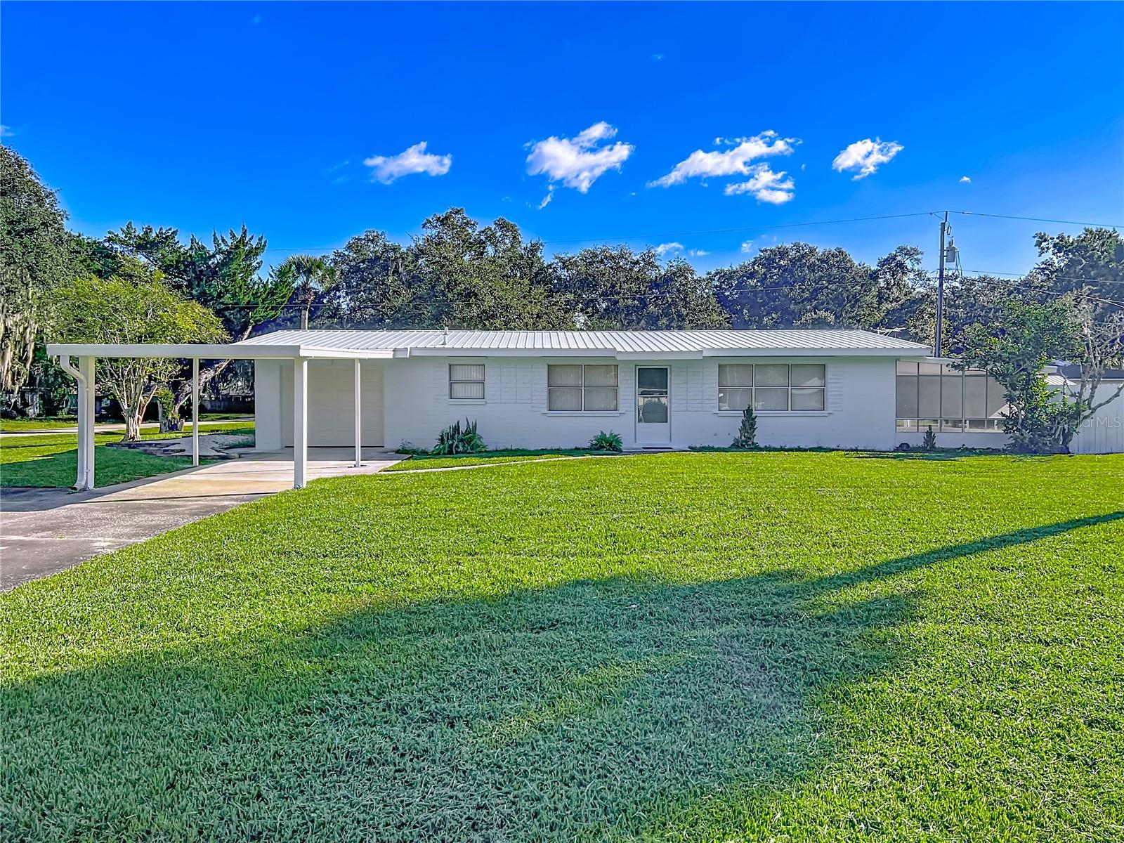This Beautiful Ranch is located in the very desirable area of Florida Shores located in Edgewater Florida. The home is located in Flood Zone X which means it is not in a flood zone and is high and dry. The Roof is metal and was installed in 2014 making it only 11 years old. The Living Room/Dining Room combination is an open concept, and the Living Room is a Large 20/14 Feet. The Living Room has French Doors opening to a huge Patio. The Kitchen is a Galley kitchen and has ample cabinet space and is open into the Dining Room. The appliances are a Refrigerator, Range, dishwasher and a Microwave. The Bedrooms are located in the rear of the home which makes them both Private and Quiet. The Lovely Bathroom is Tiled and has a Tub and Shower Combination. The Flooring is Very Nice Terrazzo Flooring and is throughout the home. The Kitchen door opens into the garage which makes bringing groceries home easy. In the rear of the garage is the laundry room with a half bath. The lot is 1/3 of an acre and has fencing and a huge shed for strorage and lawn equipment.