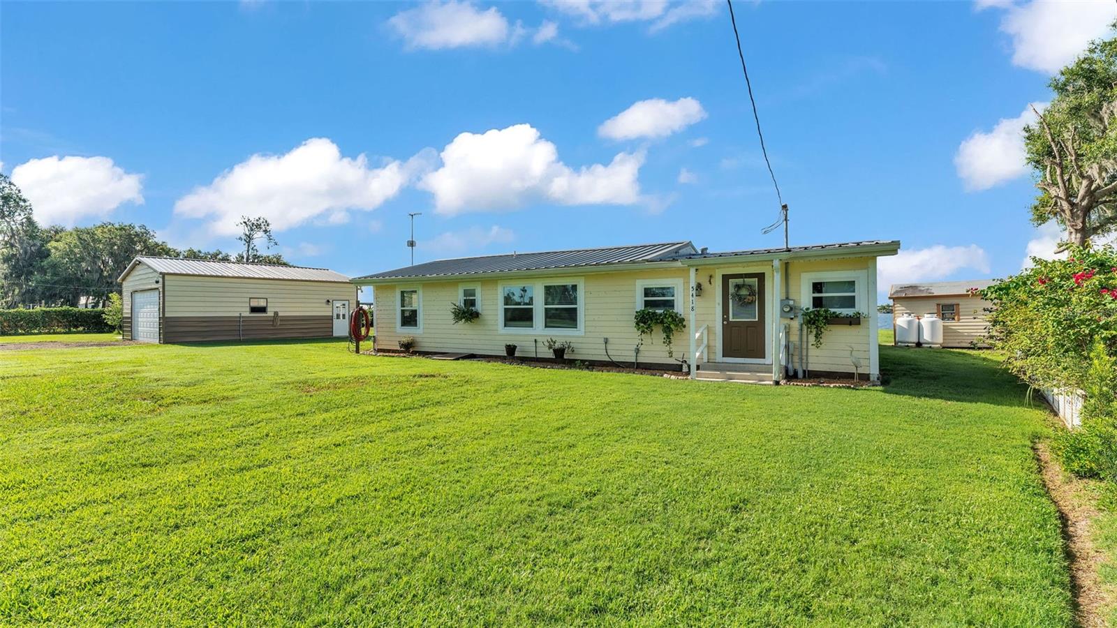 RARE LAKEFRONT GEM WITH **NO HOA** and brand new dock built June 2025! Welcome to this beautifully remodeled home nestled on the shores of Lake Buffum. Offering peace, tranquility, and breathtaking sunset views, this move-in-ready 3-bedroom, 2-bathroom home has been completely renovated from the subfloor up, within the past three years! Situated on 1.22 acres with 160 feet of lake frontage, this property provides ample space for your boat, jet skis, and recreational vehicles. Plus, with a whole-home GENERAC generator, you'll never have to worry about power outages again! Step inside to discover a gorgeous, fully remodeled kitchen, featuring high-end cabinetry, granite countertops, tile backsplash, recessed lighting, modern fixtures, and stainless steel appliances. The open-concept living areas boast beautiful porcelain wood-look tile flooring, while plush carpeting adds comfort to all three bedrooms. Designed with a triple-split floor plan, this home offers both privacy and functionality. The spacious primary suite includes his and hers walk-in closets and a luxurious en suite bathroom with a jetted tub and a large, glass-enclosed tiled shower. Additional upgrades include: double-pane windows, durable metal roof, spacious indoor laundry room, Freshly painted exterior, just to name a few. Enjoy the Florida lifestyle from your brand-new large screened-in lanai—the perfect spot to relax and take in the stunning lake views. Need extra space? A detached 24x30 garage/workshop, built in 2023, offers power and plenty of room for projects or storing your toys. After you enjoy a day on the lake you'll find a fish cleaning station, and more storage in the pump house/ shed. Whether you're unwinding on the porch, casting a line for bass, or hitting the water on your boat or jet ski, this home truly embodies lakefront living at its finest. Located near the brand new public boat ramp at 2808 Doc Lindsey Road, where lake access and parking your trailer are a breeze. Don’t miss out—schedule your showing today!