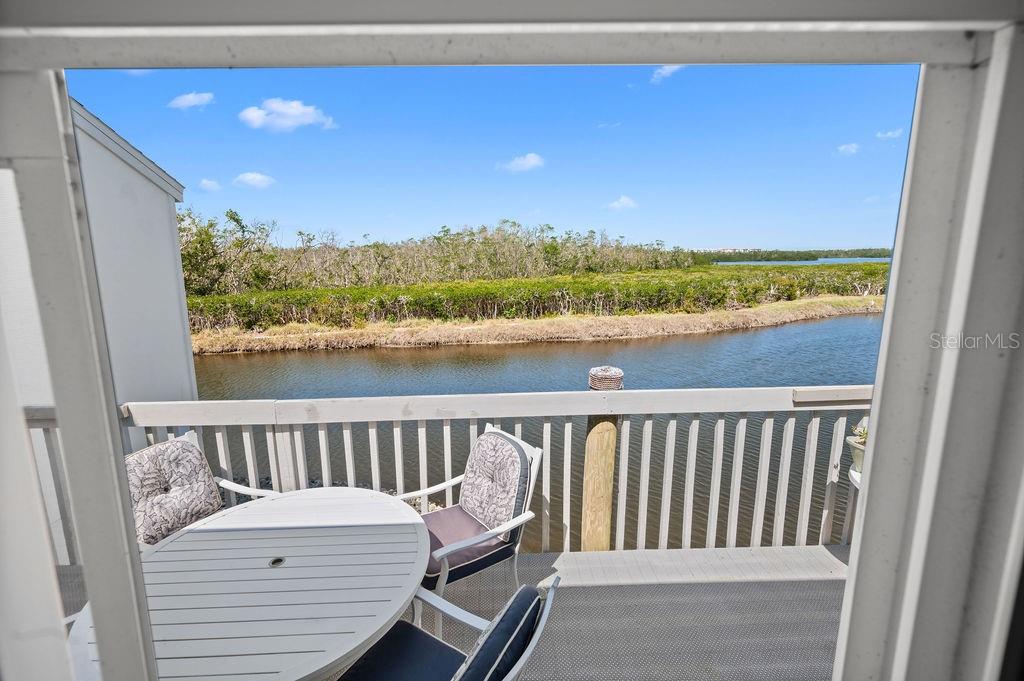 BRAND NEW A/C ~~~ PRIVATE WATER VIEWS to the preserve! ~~~ FULLY FURNISHED! ~~~ TWO CAR garage!!
Keep your cool throughout your open floor plan, while you enjoy your living room's private water view with your NEW AC! You will love the resort style amenities and the privacy of your own waterfront villa in this Perico Bay Club 2 bed/2 bath/2 car garage with a 2022 roof! This furnished home invites you in with high ceilings and an extended open floor plan with large white tile flooring throughout! The 1453sf of living space accentuates the wall of sliders to your private deck, open to the serenity of the Preserve! The kitchen view has been opened up to enjoy the living space and bar seating at the high counter. The fully stocked kitchen has ample white cabinetry and solid surface counters, easy access to your full washer and dryer and large kitchen windows with views to your private courtyard. Your bedroom has its own slider to your private, full length back porch, as well as volume ceilings, a walk in closet, and a glass enclosed walk in shower en suite! Your guest suite also enjoys the high ceilings, and a walk in closet with extra shelving. And you will love your built-in lighted display in your living room cabinetry. All of this in the gorgeous gated community of Perico Bay Club with clubhouse, pickleball/tennis courts, kayak launch, fitness room, community library, lap pool, and more...only 2 miles to the beaches of Anna Maria Island!