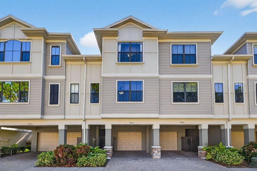 Welcome to the private, gated community of Pelican Pointe that backs up to lush conservation wetlands along Old Tampa Bay. This extremely well-kept community is conveniently located near everything Tampa Bay has to offer. Each unit has its own private gate to the home. Upon entering the townhome, you will immediately notice the beautiful engineered hardwood floors throughout the entire home. There is sleek stair railing on all the stairs as well. On the main living floor, there are two living spaces with the kitchen and dining room in between. The space is great for entertaining. The kitchen features modern cabinets, granite countertops, stainless steel appliances, a large island, and plenty of storage. Off the rear living room is a completely private enclosed patio looking out over the serene pond that is surrounded by cypress trees. This townhome is one of the few in the community where the covered patio is enclosed with its own windows (not just screens) to allow for extra privacy. The rear family room has a stunning feature wall with a built-in electric fireplace surround. Just up a few steps from the kitchen is a perfectly placed guest half bathroom. Up the stairs to the third floor, you'll find a large primary bedroom, bathroom, and walk-in closet. The primary bedroom also overlooks the pond and trees. The primary bathroom has been upgraded in recent years with neutral tile throughout,a shower glass enclosure, newer fixtures, and a large walk-in closet through the bathroom with a custom closet system. The guest bedroom is at the front of the home along with a hall guest bathroom, and a laundry closet. There is a gleaming community pool and facilities solely for the residents of the community. The HOA covers the roof, exterior painting/maintenance, water, sewer, exterior pest control, lawn care, and trash. The tandem garage spans the entire length of the townhome and has additional built-in storage. There is a small paver patio out the back of the garage as well. This townhome is 10-15 minutes to Tampa International Airport, 20 minutes to downtown Tampa, 35-40 minutes to the Gulf beaches, and all the entertainment and restaurants you could ask for.