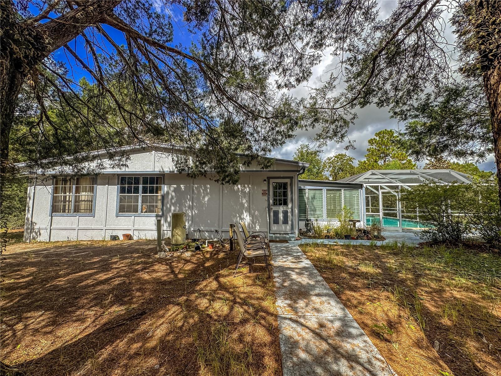 Have you been looking for a place with lots of space and peace and tranquility? Look no further! This spacious, well taken care of mobile home is tucked away in the woods, where you can sit and listen to the birds and and the beauiful melody of your wind chimes. Conveniently located close to all amenities, such as schools, hospitals, doctor offices, restaurants and shopping. This 5 acre parcel offers you the charm of living in the country but still being close enough to civilization. This property has a 2 car detached garage and a huge barn to tinker on your projects or to store your toys. Relax in the 18x38 inground pool after a hard day at work. This property has so much to offer. Schedule a showing today!