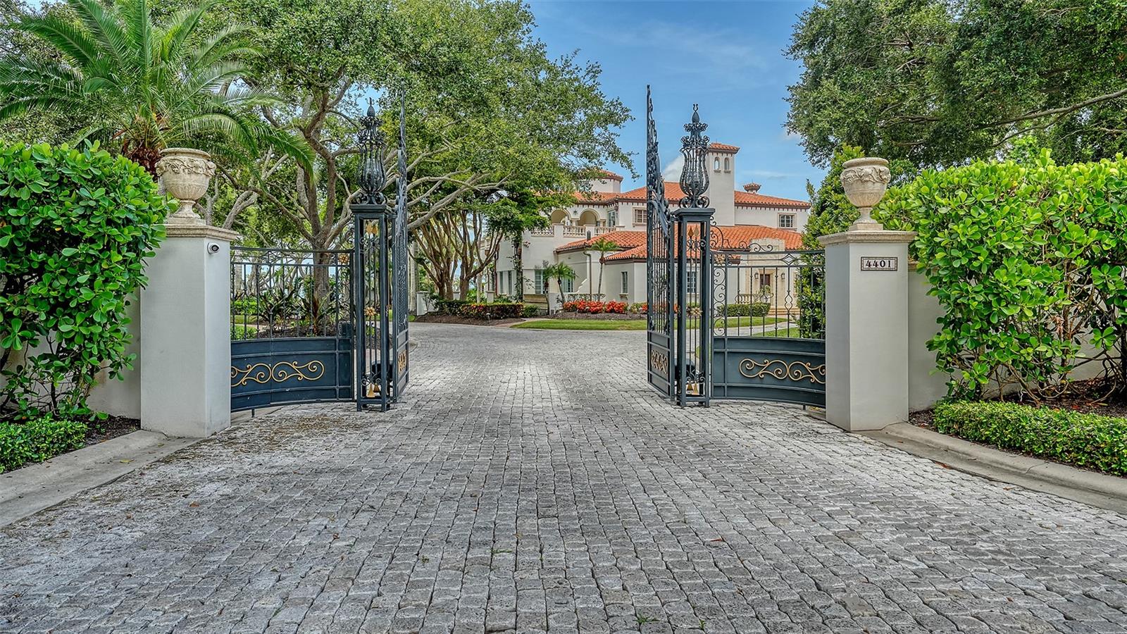 One of the most exceptional Bayfront Estates on Florida’s west coast, offering sweeping Sarasota Bay views and unforgettable sunsets over Longboat Key. This gated waterfront retreat features a private beach, lush tropical landscaping, and a stunning courtyard with pool perfect for both entertaining and quiet enjoyment.
Plans by a renowned architect Landry design group are available to reimagine the estate, which already boasts custom interiors, soaring thirty foot ceilings, intricate imported ironwork, and fine wood craftsmanship. The gracious entertaining spaces open to a lavish terrace with a fifty-foot lap pool, two outdoor kitchens, an elegant bathhouse, koi pond, and a private spa.
This rare waterfront sanctuary combines total seclusion with unbeatable convenience — minutes from Sarasota Airport, downtown, the Ringling Museum, Longboat Key Club, and pristine beaches. A one-of-a-kind opportunity you don’t want to miss.