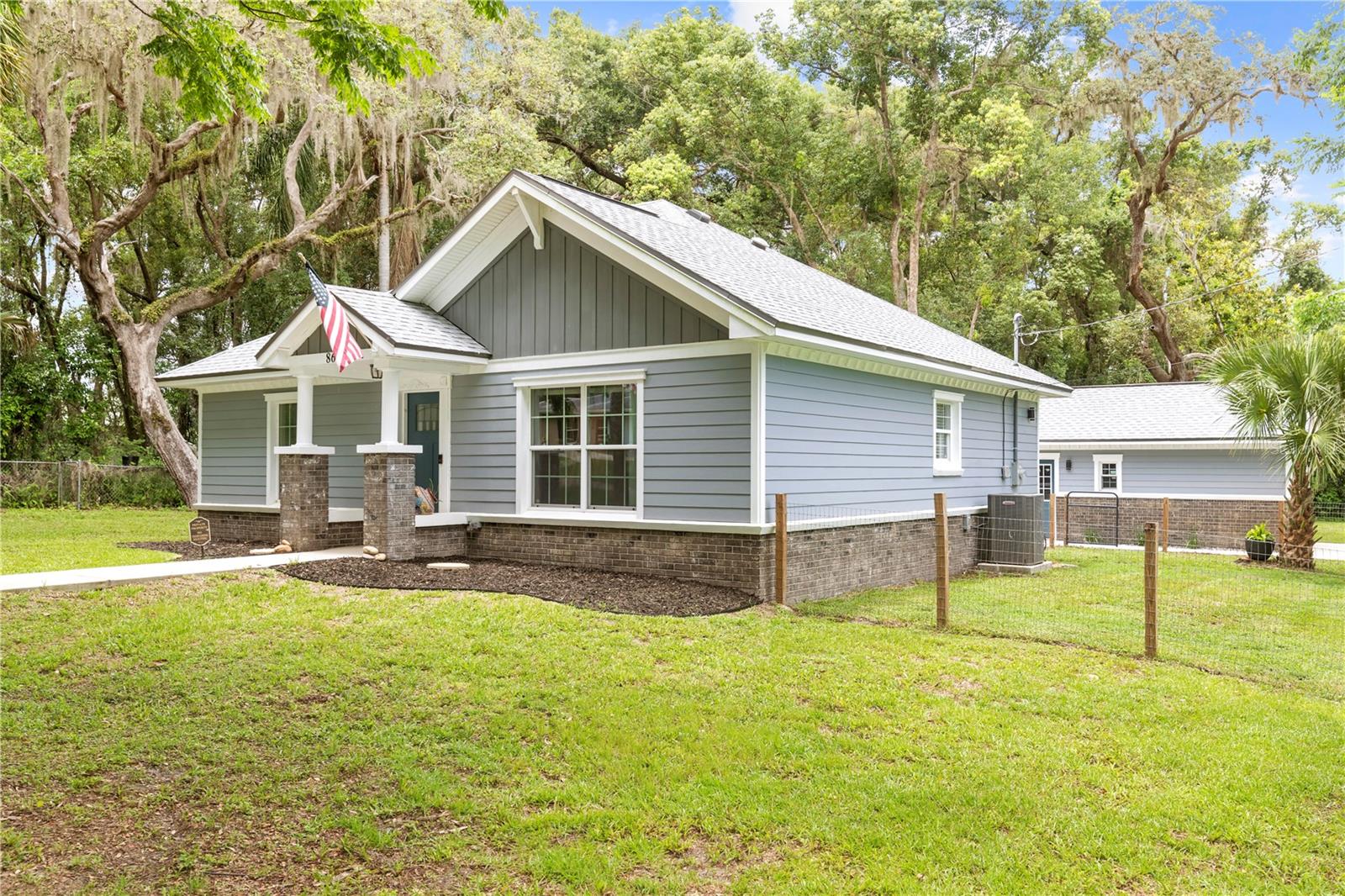 Welcomed by majestic oaks canopying the streets in the heart of Floral City, this newer construction farmhouse is now available! This spacious home with cathedral ceilings feels significantly larger when you see it in person! This beautiful home with a detached garage sits on a double corner lot on over 1/3 of an acre. This entire home was rebuilt down to the slab in 2023 making it practically new construction and giving the new owners peace of mind. You are greeted through the front door with cathedral ceilings and a completely open floor plan - perfect for entertaining! This home has tons of natural lighting throughout. The kitchen has plenty of cabinetry along with stainless steel appliances and a breakfast bar. Both bedrooms are of great size and the spacious bathroom has a beautifully tiled shower/tub combo. Enjoy coffee or wine on the large back porch with complete peace and quiet and lots of wildlife. This property features a detached 1 car garage on a slab with plenty of driveway parking. The roof, electrical, plumbing, windows, septic tank & drain field were all replaced in 2023! This property has no HOA and is NOT in a flood zone! This home is located just 3 blocks from the Withlacoochee State Trail, just 1/2 mile to the Duval Island boat ramp & just a few miles to the stunning Withlacoochee River. This beautiful home in the quaint historic town of Floral City is move-in ready and truly a great place to call home!