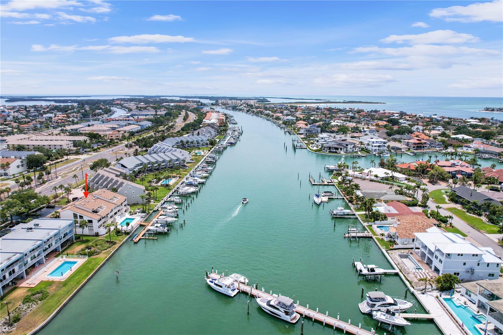Experience the ultimate waterfront luxury in this exquisite condo nestled along the Grand Canal in Tierra Verde. The private deeded boat slip with a 20,000 lb. lift accommodating a 50’ boat enables this residence to seamlessly combine elegant living with waterfront convenience. The soaring cathedral ceilings adorned with ship lap and skylights create a bright, airy nautical ambiance, framing stunning water views from every angle. The expansive living room, two large bedrooms, and versatile loft area—all featuring charming sloped ceilings—provide flexible spaces for relaxation, work, or guests. The second bedroom’s nautical round window accentuates the coastal vibe, while the primary suite features dual walk-in closets and a private balcony perfect for savoring sunset over the water while the luxurious travertine floors and beautifully updated kitchen imbue the home with elegance and warmth. Enjoy the Florida lifestyle from the generous balcony off the kitchen with stairs leading down to the pool and dock. Additional features include hurricane shutters for peace of mind, a sizable 350+ square foot storage room ideal for kayaks, paddle boards, and boat gear, plus a one-car garage with a loft for extra dry storage and an assigned front parking spot. The quaint community offers just eight units, ensuring privacy in your new, quiet home. With dual AC systems to keep you comfortable upstairs and down, this residence truly feels more like a dream home than a condo—an exceptional waterfront retreat waiting for you.