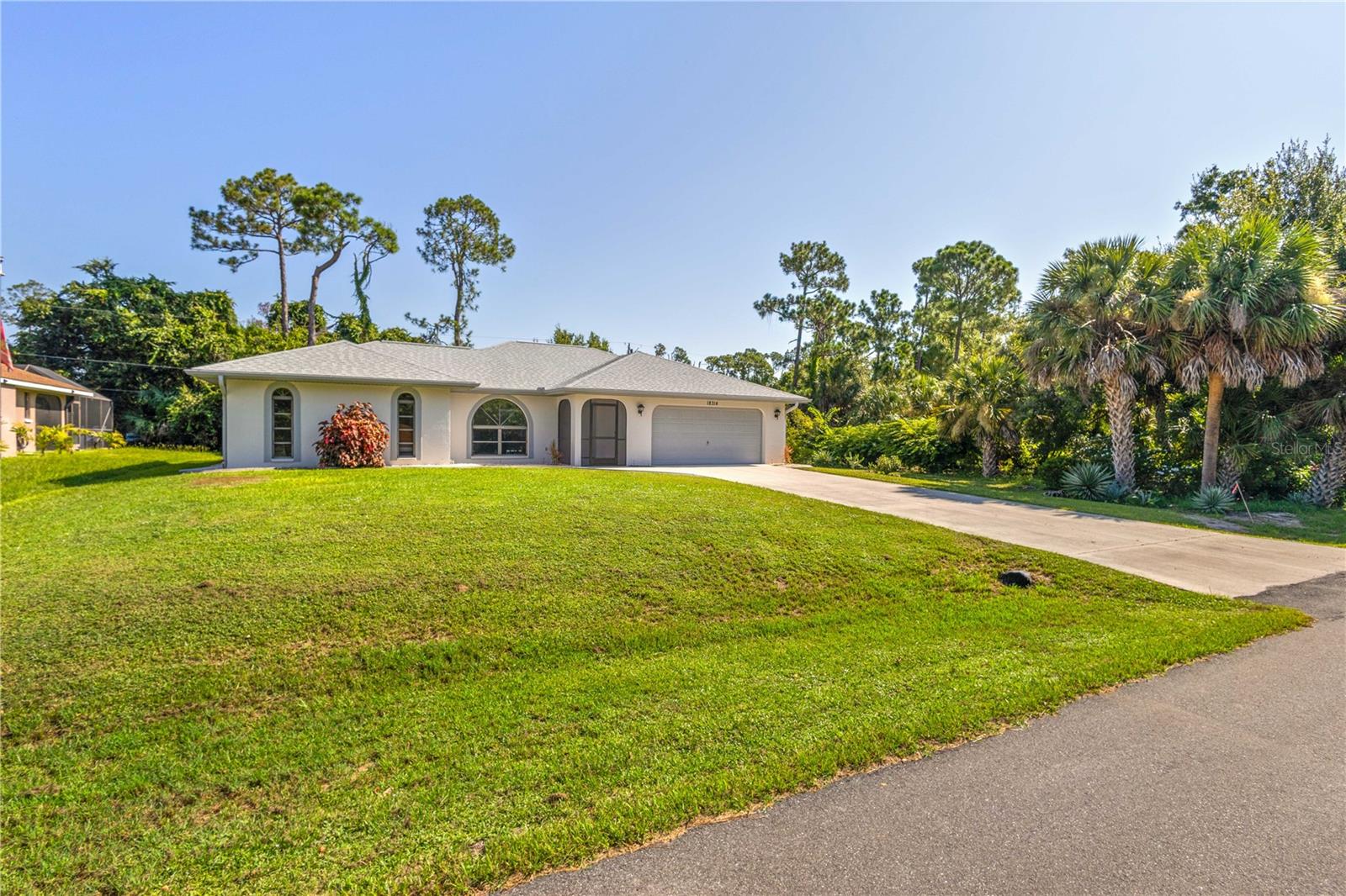 Welcome Home! This beautiful well maintained home is being sold furnished and is situated on a double lot. Move right in and start enjoying the Florida lifestyle. From the minute you walk through the screened entryway into the living room you will notice the open floor plan with large living room, dining area and a view of the lanai and pool. The living room boasts a cathedral ceiling, large windows to let the Florida sunshine in and a seamless flow to the dining area, adjacent to the kitchen. The kitchen /dining area includes 3 pocket sliders that open past the kitchen sink and counter to create a pass though to the lanai. Walk through the sliding doors and take-in the heated pool, the 23x10 under roof area and an attached adjacent 12x10 screened in lanai. Ideal area to swim, entertain, relax or grill out for you and your family and friends. The 3rd full bathroom is ideal for a guest bath or pool bath and conveniently located off the lanai. The wooded lot behind the house affords privacy. This split bedroom floor plan offers 2 large primary suites featuring ensuite bathrooms with large showers and roomy walk-in closets. The primary suite has sliding glass door access to the lanai and pool area. The adjacent lot included in the sale provides extra space for privacy, gardening, a shed or an additional home. The 2 car garage houses the washer, dryer and laundry tub. Other features include a new roof in 2023, laminate and ceramic tile flooring, a large pantry and linen closet providing ample storage, concrete curbing and rocks in plant beds around entire house, all furnishings and items in house and a solar pool cover for the cooler months. Nice and quiet neighborhood to walk or ride your bike and enjoy nature and the wildlife. Convenient location with stores, restaurants, movie theatre, bowling and boat ramp within 3 miles. No HOA. Take a look at this home, you won't be disappointed. Video attached for your viewing pleasure.