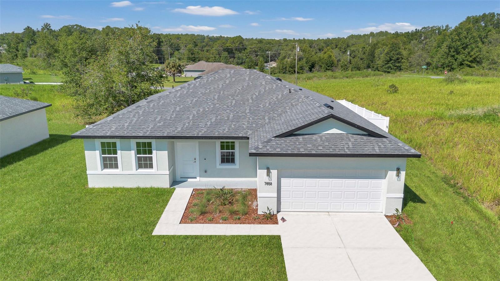 This brand-new, affordable 4-bedroom, 3-bathroom new construction home in Citrus Springs has been completed and is ready for a new owner. Newly installed privacy fence! No neighbors directly behind. 9’4" foot ceilings throughout! County water is available. No flood insurance necessary. Conveniently located right next to Withlacoochee Trail, and near schools, main roads, and shopping. The kitchen is equipped with granite countertops, stainless steel appliances, an island with a double bowl stainless steel sink, a Moen faucet, a garbage disposal, and 36-inch cabinets. Enjoy upgraded ceramic tile floors throughout, and granite countertops in the bathrooms. Experience elevated living in this exquisite new construction home. This model offers four bedrooms and three bathrooms within 1,827 square feet of thoughtfully designed space, harmonizing style, comfort, and functionality. This home is great for growing families or entertaining guests. Enjoy the freedom of a spacious lot on a hill with no homeowner association or CDD fees. Don’t miss your chance to claim this dream home – schedule a showing today and discover the perfect backdrop for your family or retirement. Home builder warranty available. Seller concessions available.