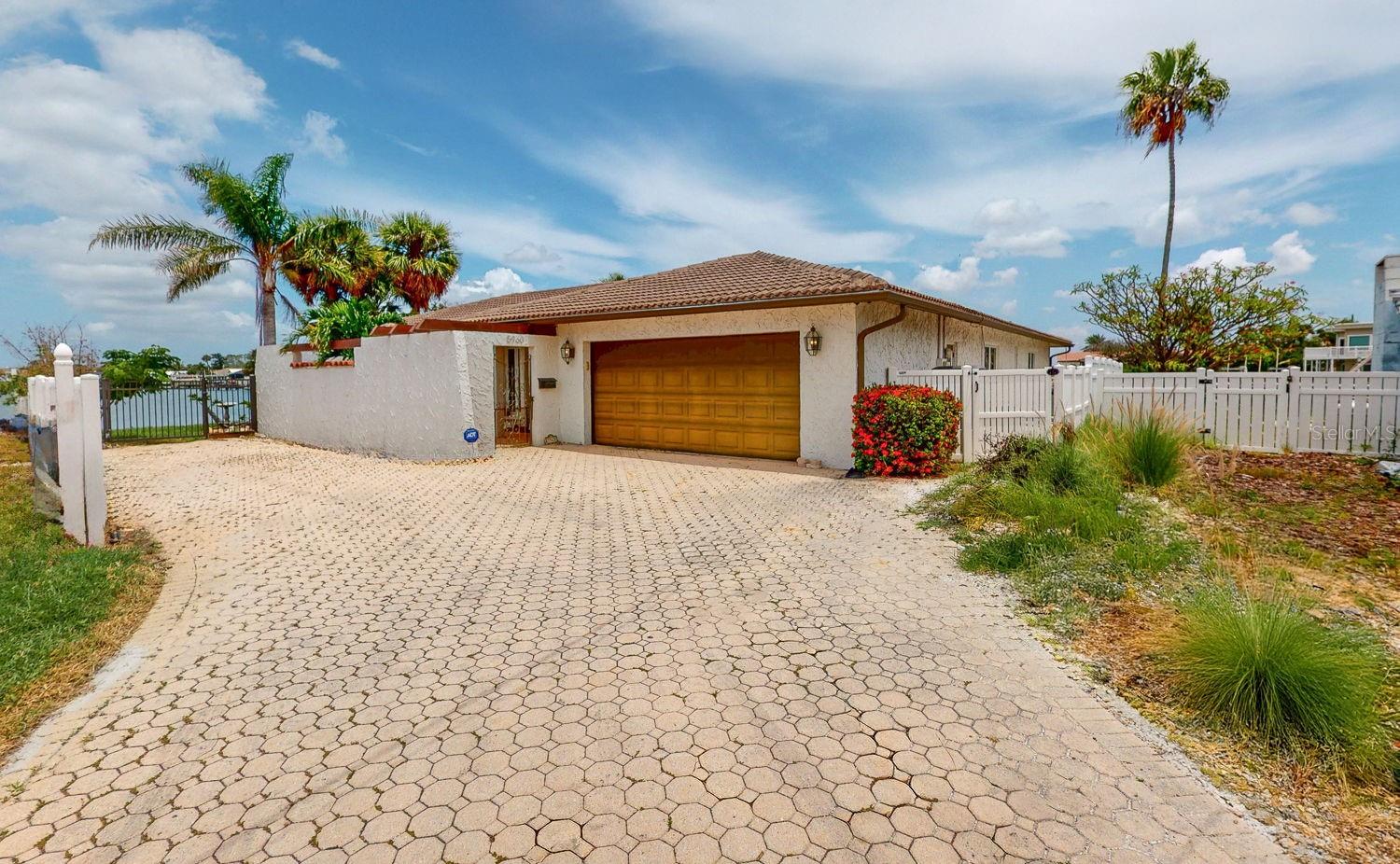 One or more photo(s) has been virtually staged. ***SELLER IS OFFERING FINANCING WITH FLEXIBLE AND VERY REASONABLE TERMS*** Welcome to waterfront living at its finest in the prestigious Bahia Shores neighborhood of St. Pete Beach! Situated on a rare corner lot with an incredible 240 feet of waterfront, this impeccably maintained 3-bedroom, 3-bath, 2-car garage pool home offers sweeping Intracoastal views from nearly every room. Move-in ready and thoughtfully updated, this tropical retreat features premium Pella impact windows and sliders, a gourmet kitchen with granite countertops, spacious living and dining areas, crown molding, and walk-in closets in every bedroom. Step outside to your private paradise with a pavered lanai and pool deck, a 15,000 lb boat lift with power—ideal for enjoying the best of Florida boating. The tile roof was replaced in 2014, and the HVAC system is just 2 years old. Located in a desirable neighborhood just minutes from sandy beaches, shops, dining, nightlife, and a quick drive to downtown St. Pete or Tampa, this home offers the ultimate blend of luxury, convenience, and coastal charm—with no HOA restrictions and Gulf access right from your backyard.