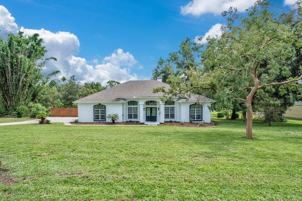 Welcome to this beautifully updated 4-bedroom, 3-full bath POOL HOME on a FULL ACRE in the sought after equestrian community Trails of Montverde! Major improvements include a NEW ROOF (2021), an UPDATED A/C & WATER HEATER, and SEPTIC SERVICED (2022) – providing peace of mind for years to come. As you step inside take note of the UPDATED FLOORING THROUGHOUT – no carpet anywhere – and a layout that balances spaciousness with functionality. The remodeled kitchen and chic bathrooms elevate the home’s style while maintaining timeless appeal. The thoughtful SPLIT BEDROOM FLOOR PLAN offers privacy for the generous PRIMARY SUITE, which features a WALK-IN CLOSET and nicely appointed private bath. Across the home, three additional bedrooms and two more full baths provide ample space for family, guests, or a home office setup. At the heart of the home, the kitchen impresses with sleek countertops, recessed and pendant lighting, desirable STAINLESS STEEL APPLIANCES and an extended BUTLER’S PANTRY, with access to both formal and casual dining areas. The breakfast bar serves as a connector, opening to a bright family room boasting a feature fireplace, French doors, and view of the COVERED LANAI and SCREENED POOL – ideal for effortless indoor/outdoor living. Formal living and dining spaces at the front of the home deliver versatility for entertaining or everyday living, while COFFERED CEILINGS, CROWN MOLDING, and lovely WAINSCOTING add refined character. This home is flooded with NATURAL LIGHT, enhancing the HIGH CEILINGS, complementary finishes, hardware and lighting choices. Outside you will enjoy a massive backyard with plenty of space to roam – or ride! With direct access to community riding trails and just a few houses down from the private RIDING ARENA, this property is ideal for horse lovers. You will also love the easy access to the Florida Turnpike, as well as nearby shopping, dining, recreation, golf, TOP RATED SCHOOLS, and so much more – making this the perfect location whether you are raising a family or looking to retire. Call today to schedule a tour and fall in love with your new HOME SWEET HOME on Thoroughbred Lane!